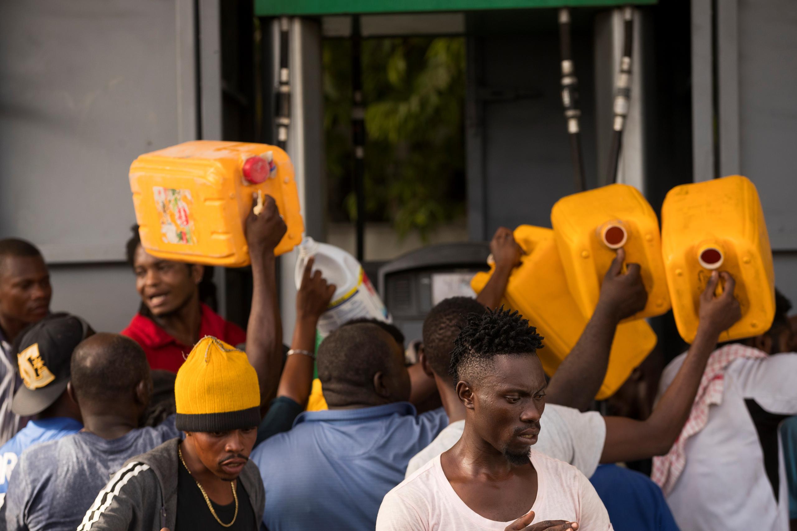 Personas intentan conseguir un poco de gasolina ante el desabastecimiento de combustibles en Puerto Príncipe (Haití).