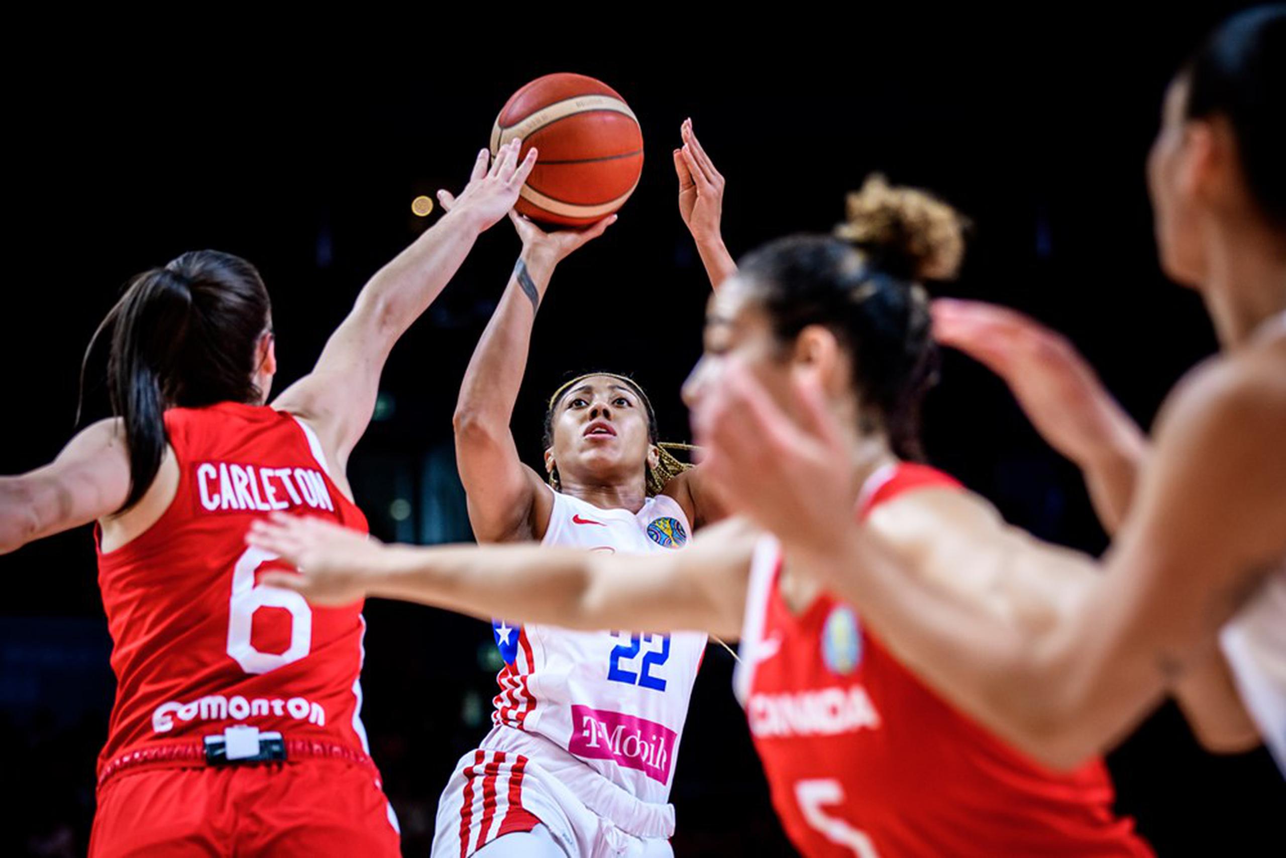 Arella Guirantes (22), de Puerto Rico, realiza un intento ante la dura defensa del equipo de Canadá durante el partido de cuartos de final del Mundial de Baloncesto femenino.