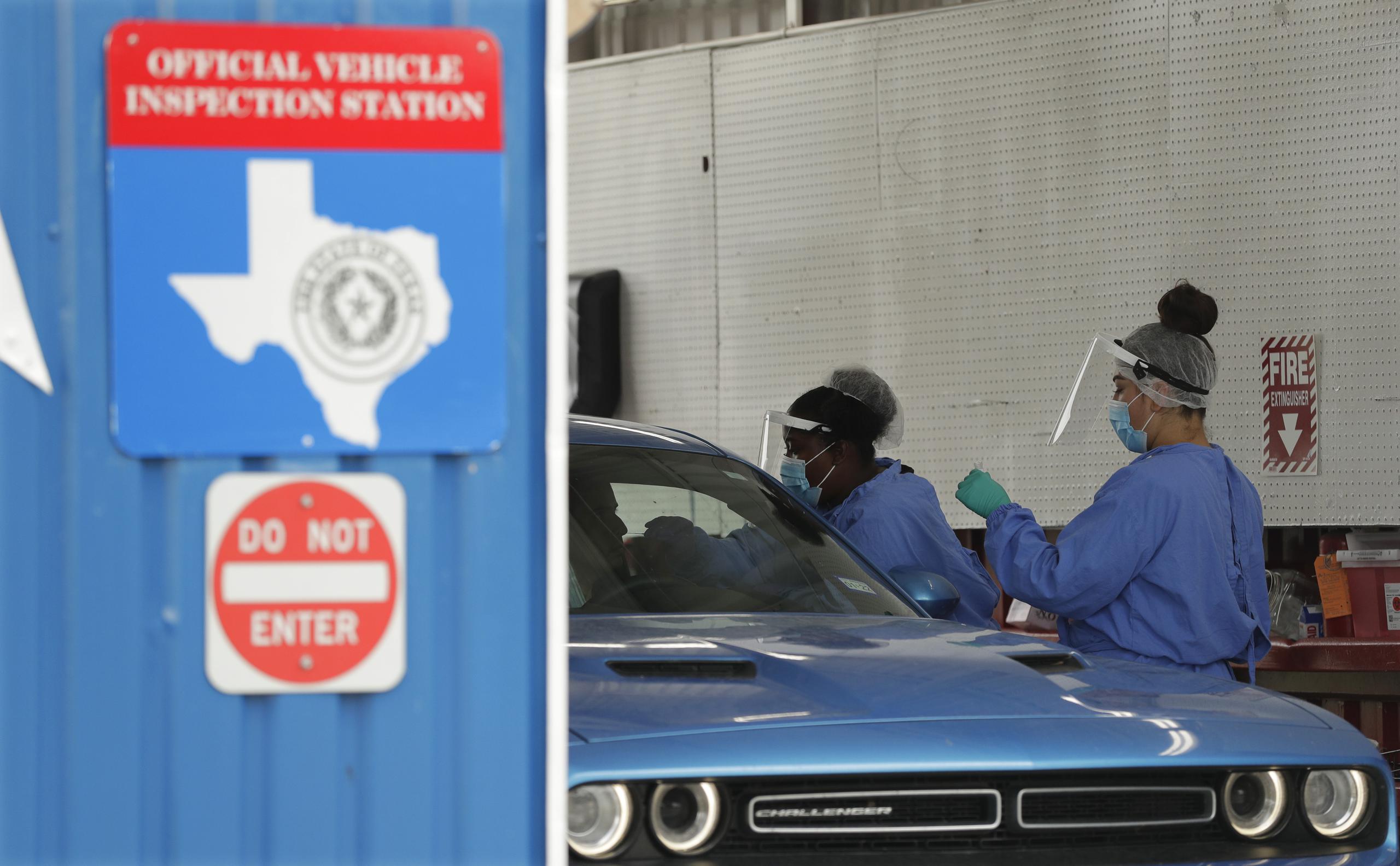 Unas personas administran pruebas de covid-19 en un centro de inspección, en San Antonio, Texas