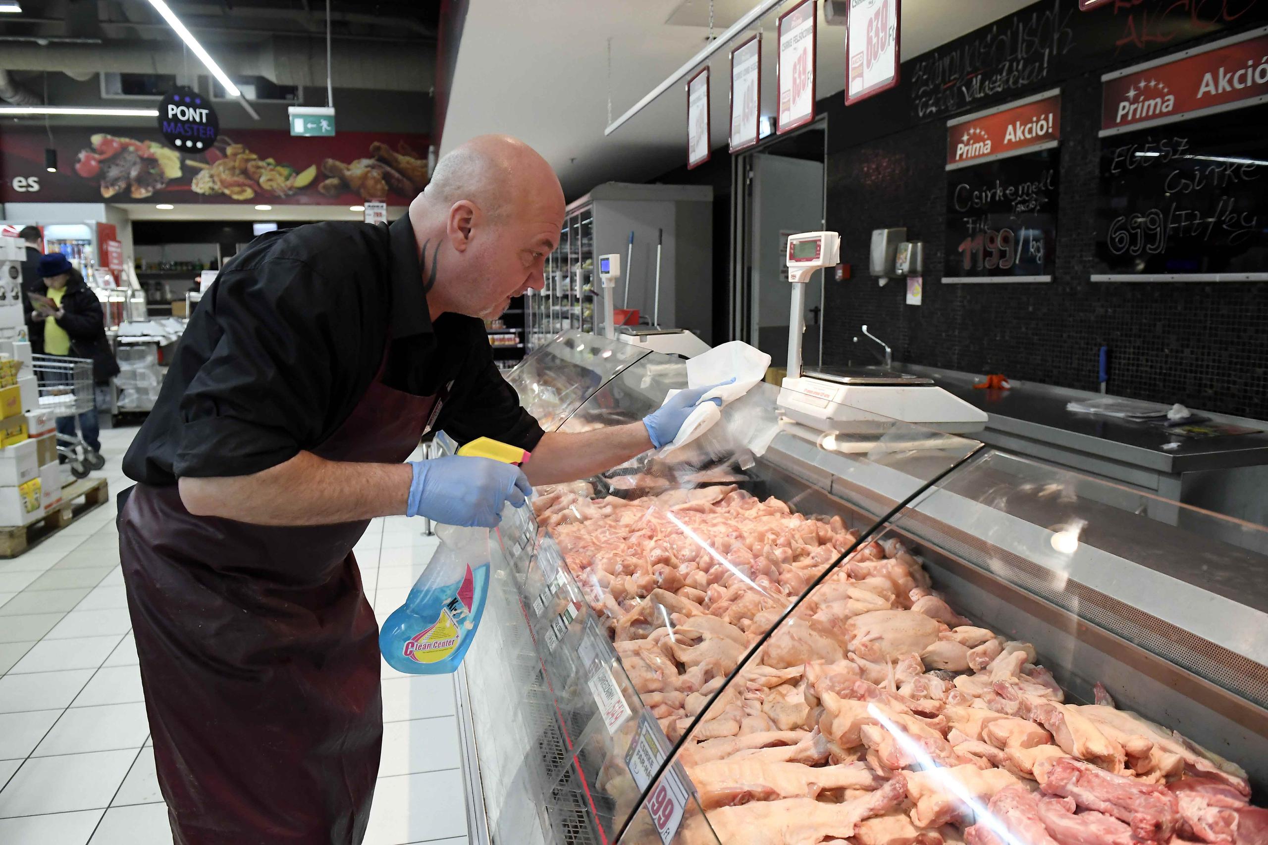 Un empleado desinfecta una vitrina en un estante de carnes en un supermercado en Budapest, Hungría, el miércoles, 11 de marzo del 2020. (Tamas Kovacs/MTI vía AP)