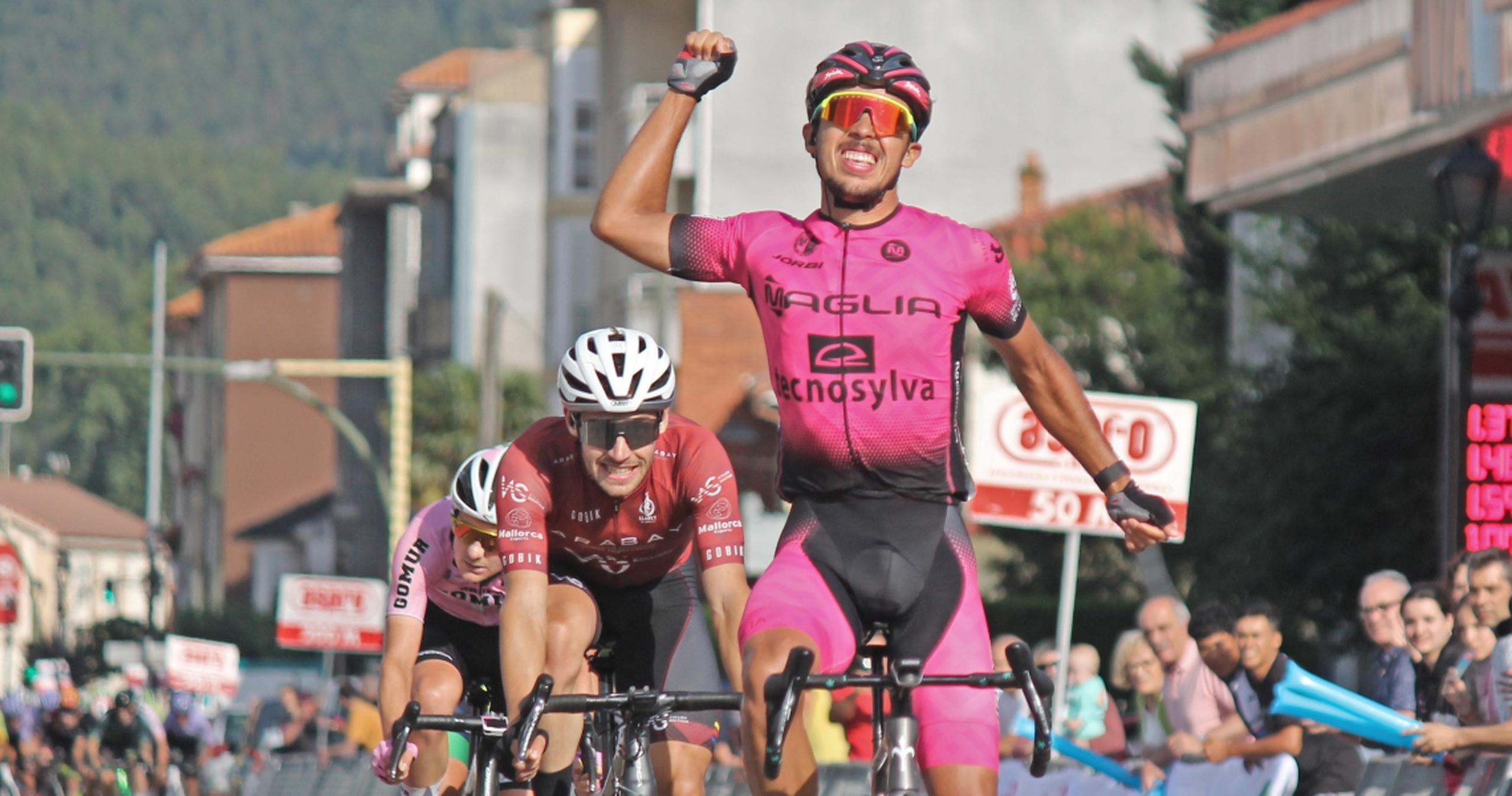 Christopher Morales levanta un brazo en señal de victoria luego de ganar la segunda etapa del corriente Circuito Montañés en España.
