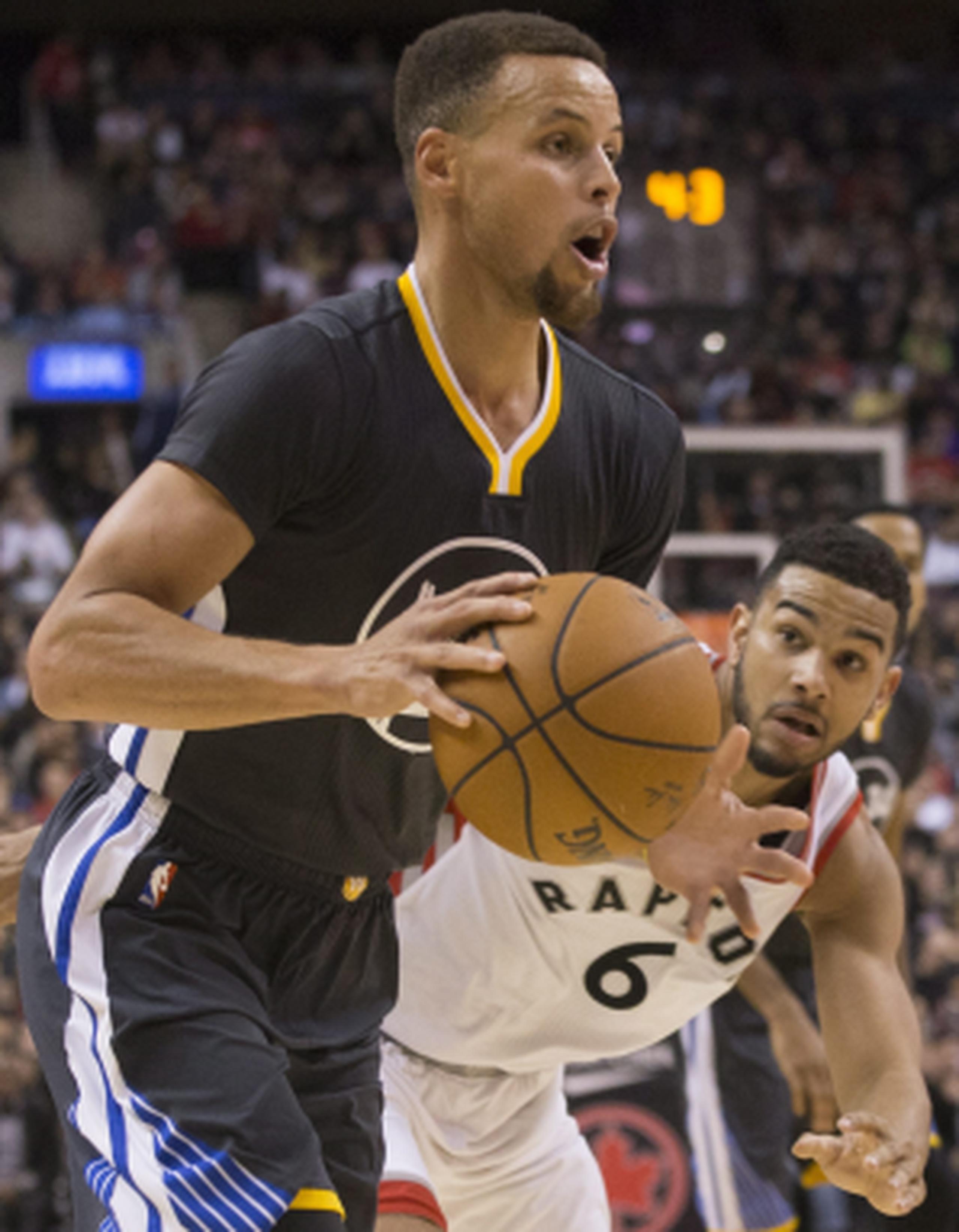 Stephen Curry, de los Warriors, deja atrás la defensa de Corey Joseph, de los Raptors durante el encuentro del sábado. Curry consiguió nueve triples en la victoria de Golden State, que ahora tiene 21-0. (AP / The Canadian Press / Chris Young) 
