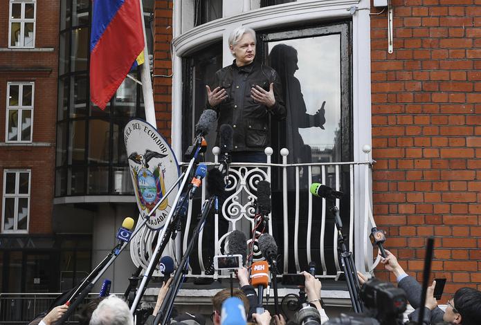 El fundador del portal web WikiLeaks, Julian Assange, al atender a medios de comunicación, desde el balcón de la embajada ecuatoriana en Londres, en el Reino Unido, donde permaneció asilado entre junio de 2012 y abril de 2019. (EFE/Andy Rain)
