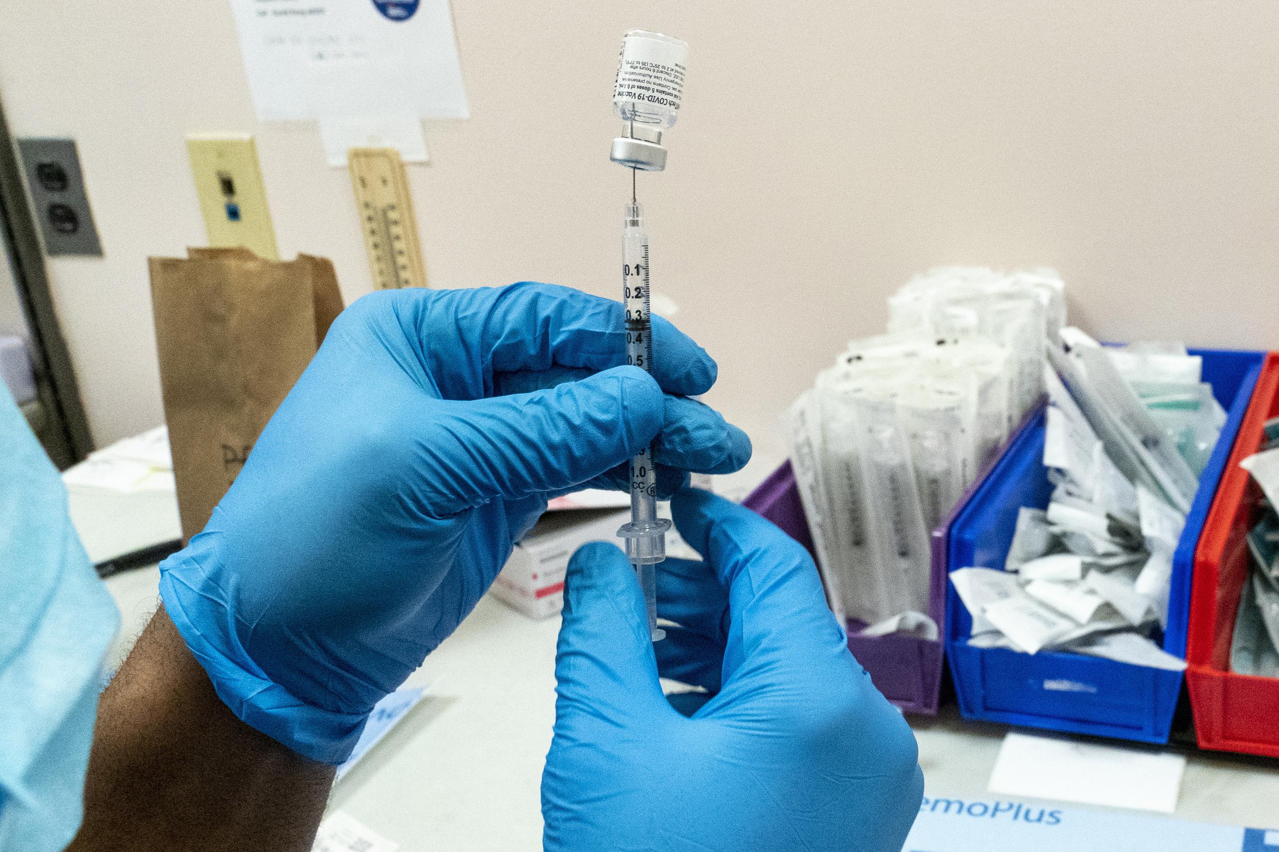Un farmacéutico prepara una jeringuilla con una dosis de la vacuna de Pfizer y BioNTech.
