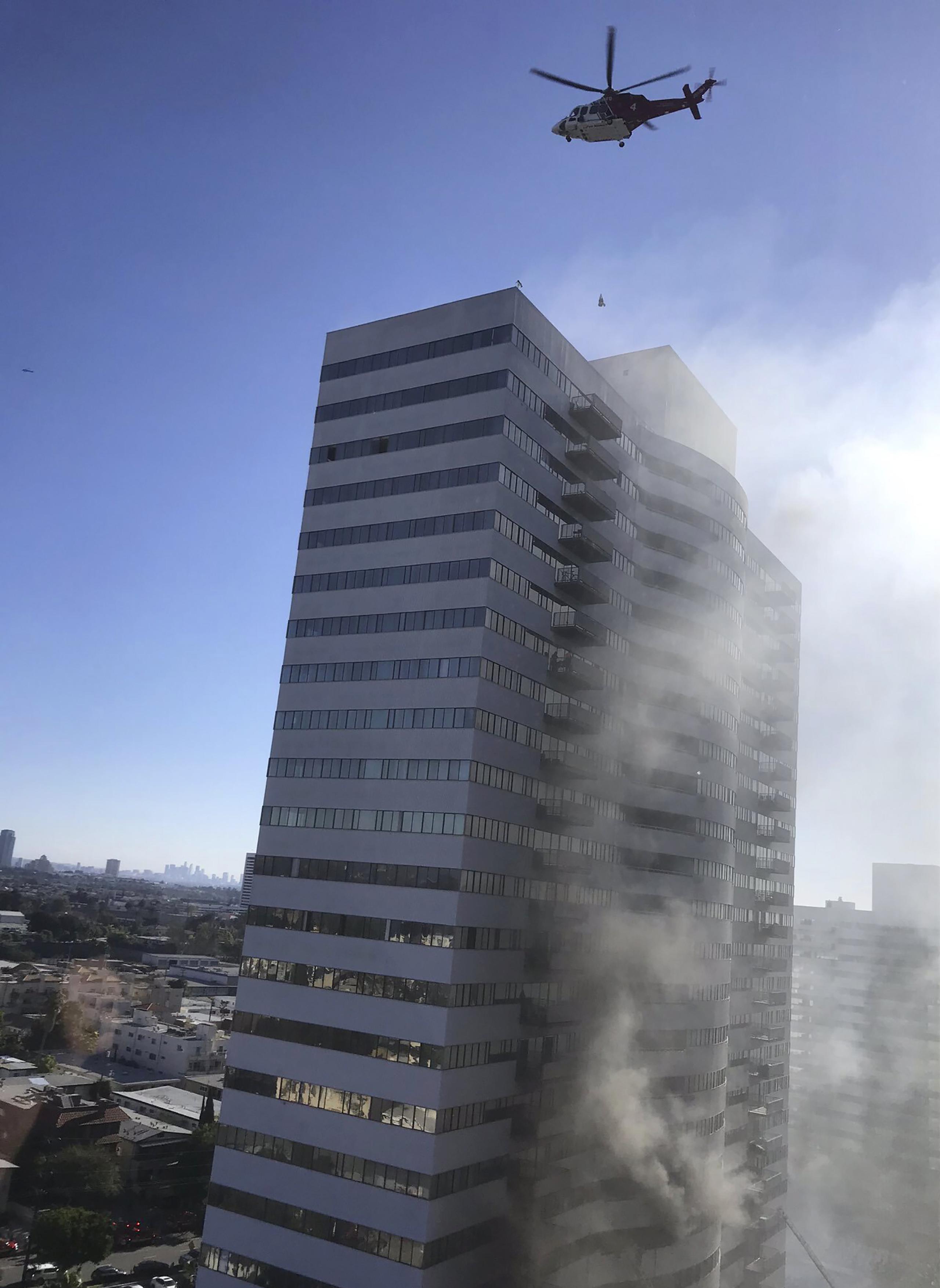 Un helicóptero de bomberos revoloteaba sobre el techo del edificio.