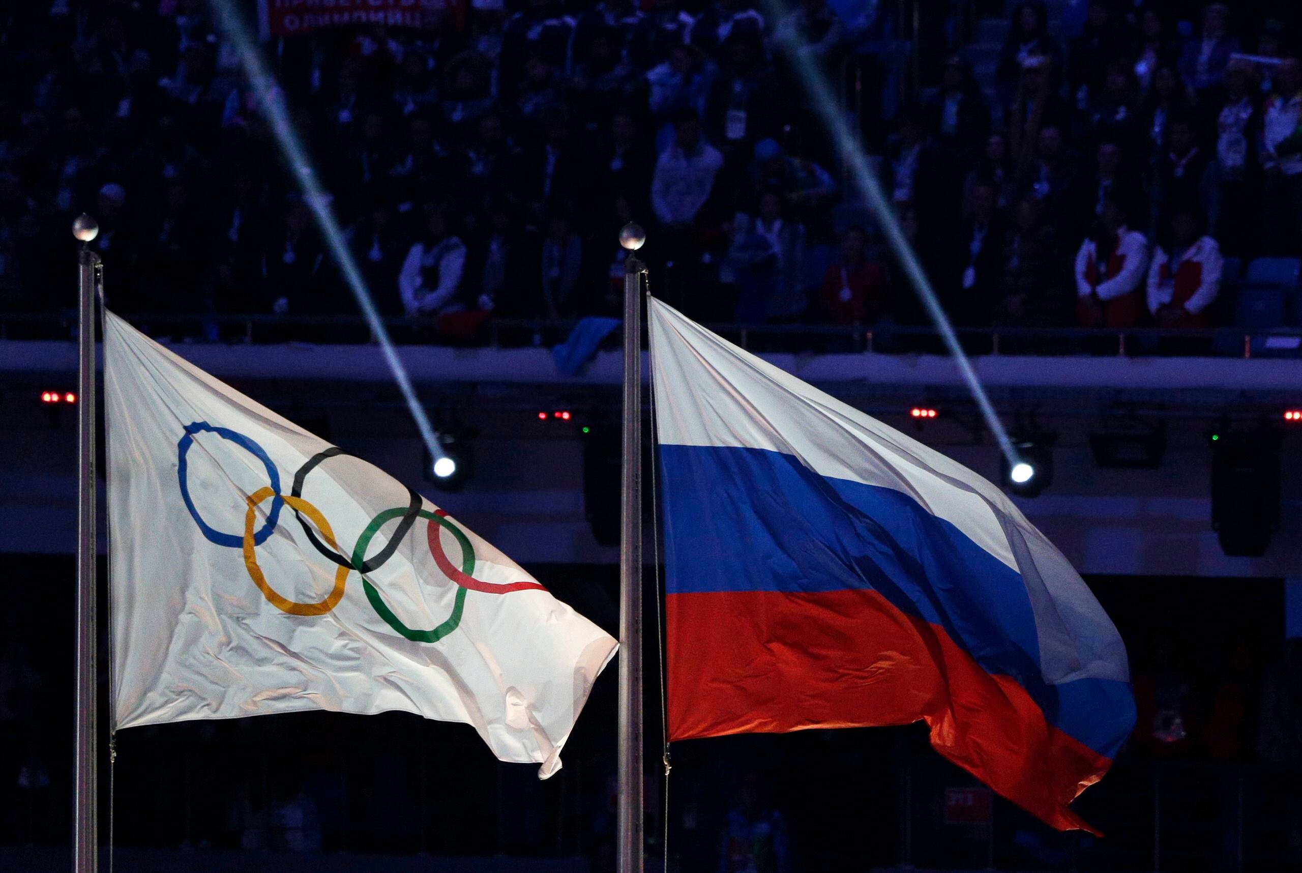 La bandera de Rusia (derecha) aparece aquí junto a la del Movimiento Olímpico durante la ceremonia de clausura de los Juegos Olímpicos de Invierno de 2014 en Sochi, Rusia.