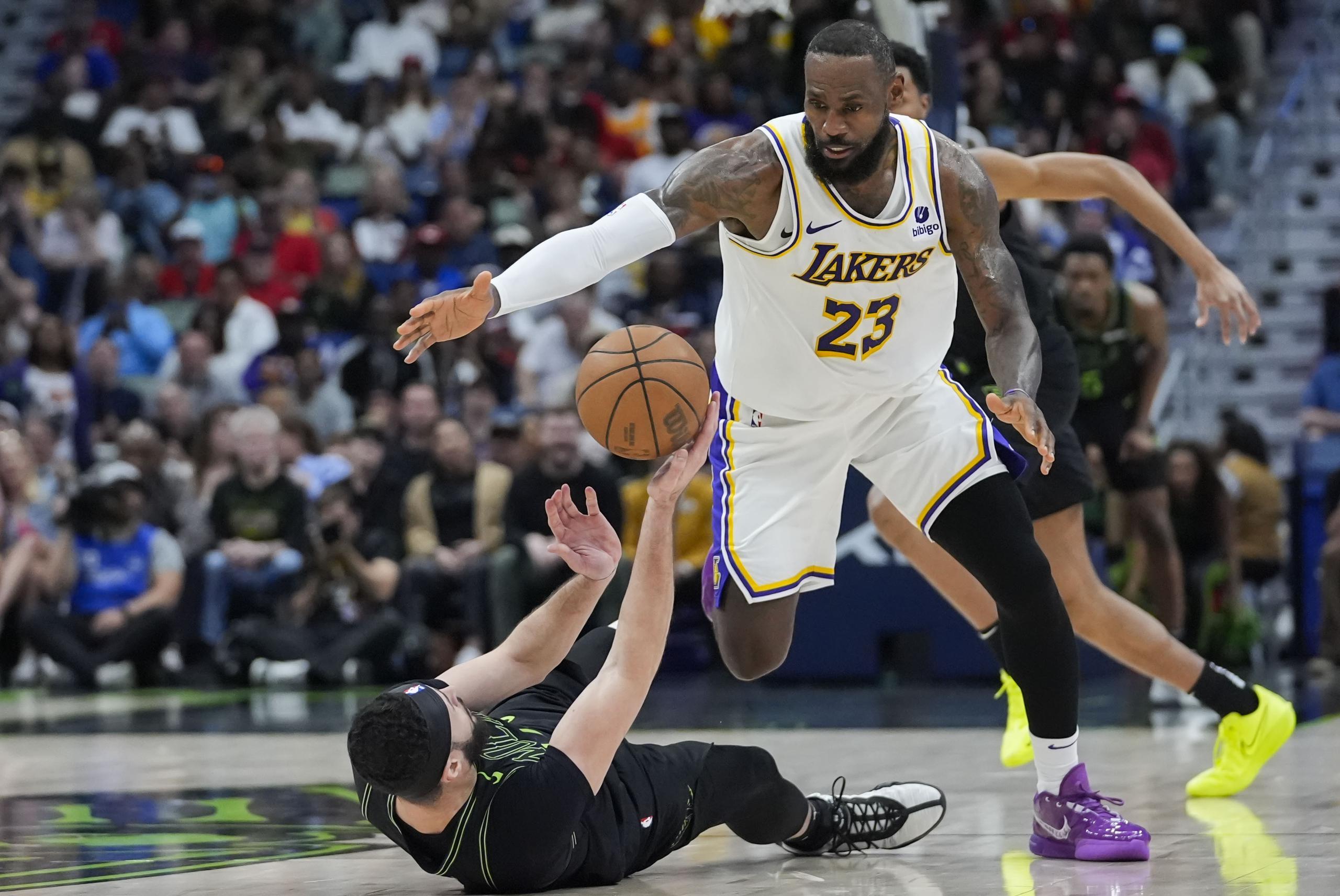 LeBron James (23), de los Lakers de Los Ángeles, se alista a robar un balón a Larry Nance Jr., de los Pelicans de Nueva Orleans, en la segunda mitad del juego de baloncesto de la NBA, en Nueva Orleans, el domingo 14 de abril de 2024. Los Lakers ganaron 124-108. (AP Foto/Gerald Herbert)