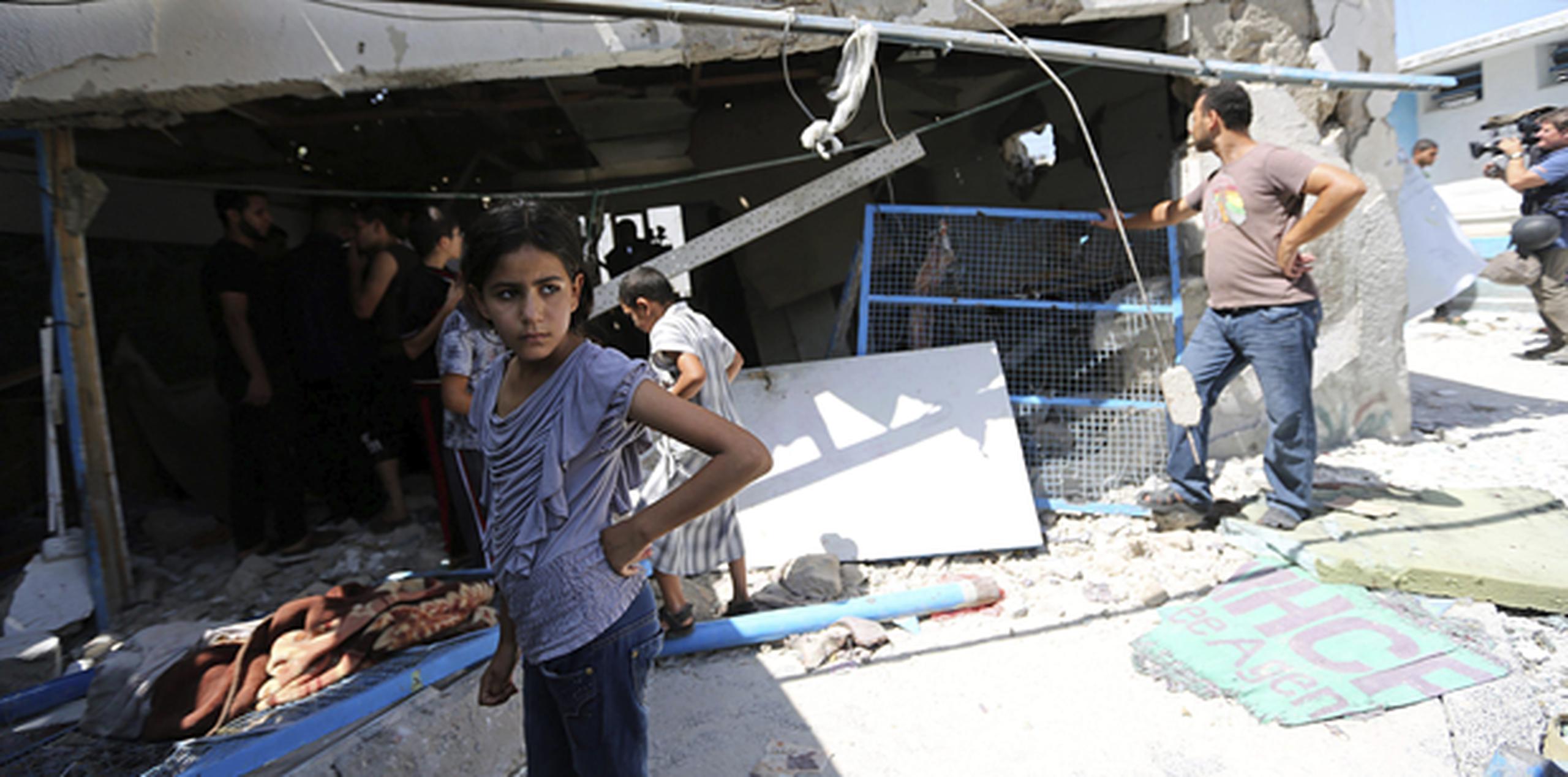 Palestinos inspeccionan una clase destruida en un colegio de la ONU en Jabalia, en el norte de la Franja de Gaza. (EFE)