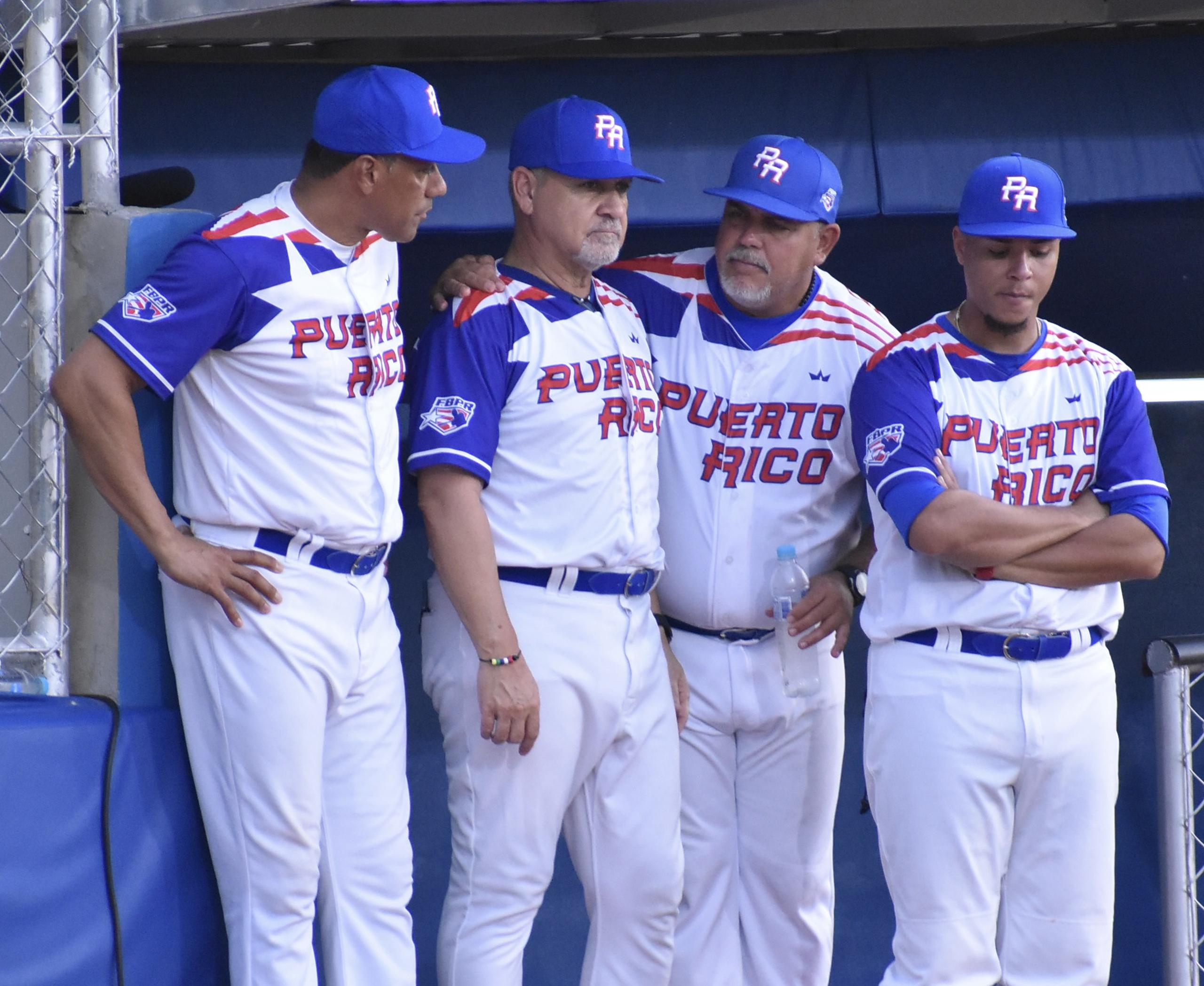 Integrantes del elenco técnico del Equipo Nacional de Béisbol en San Salvador 2023 conversa durante la acción del partido del domingo.