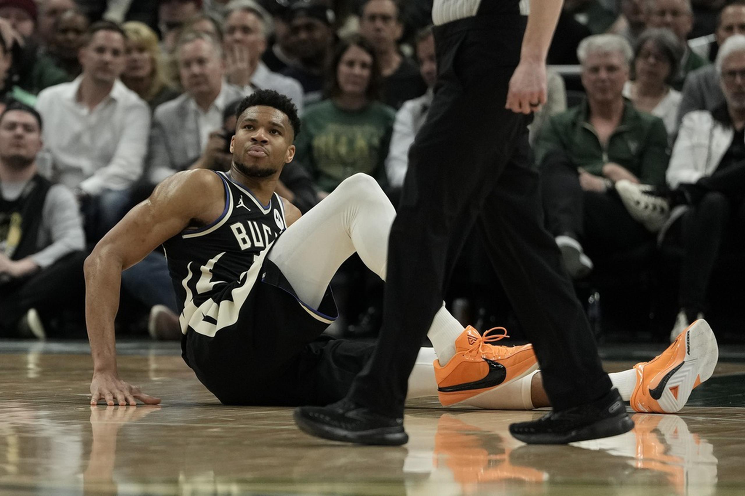 Giannis Antetokounmpo, de los Bucks de Milwaukee, se sienta en la cancha durante el partido ante los Celtics de Boston.
