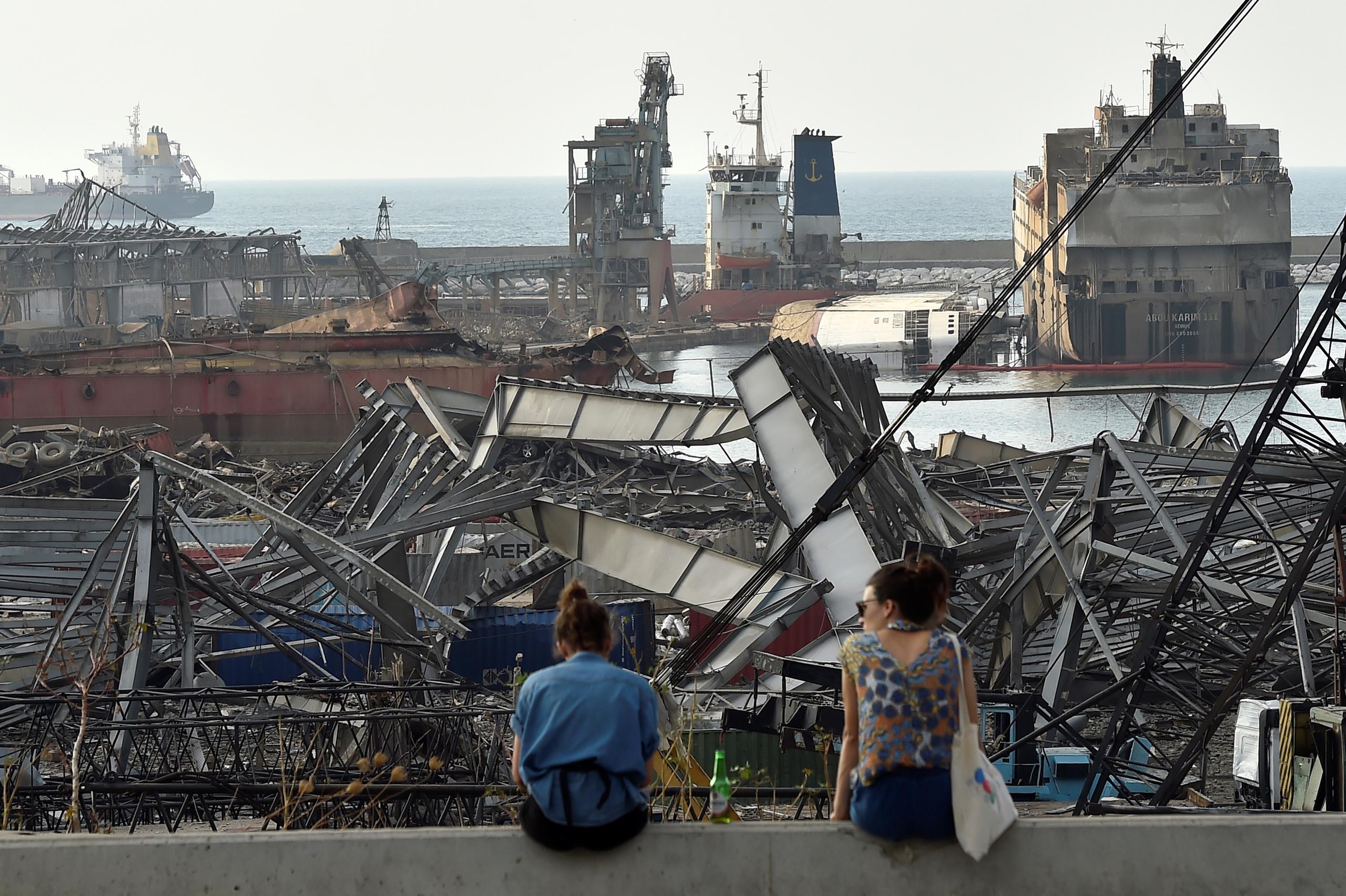 Dos mujeres observan a la distancia el lugar de la explosión en Beirut.