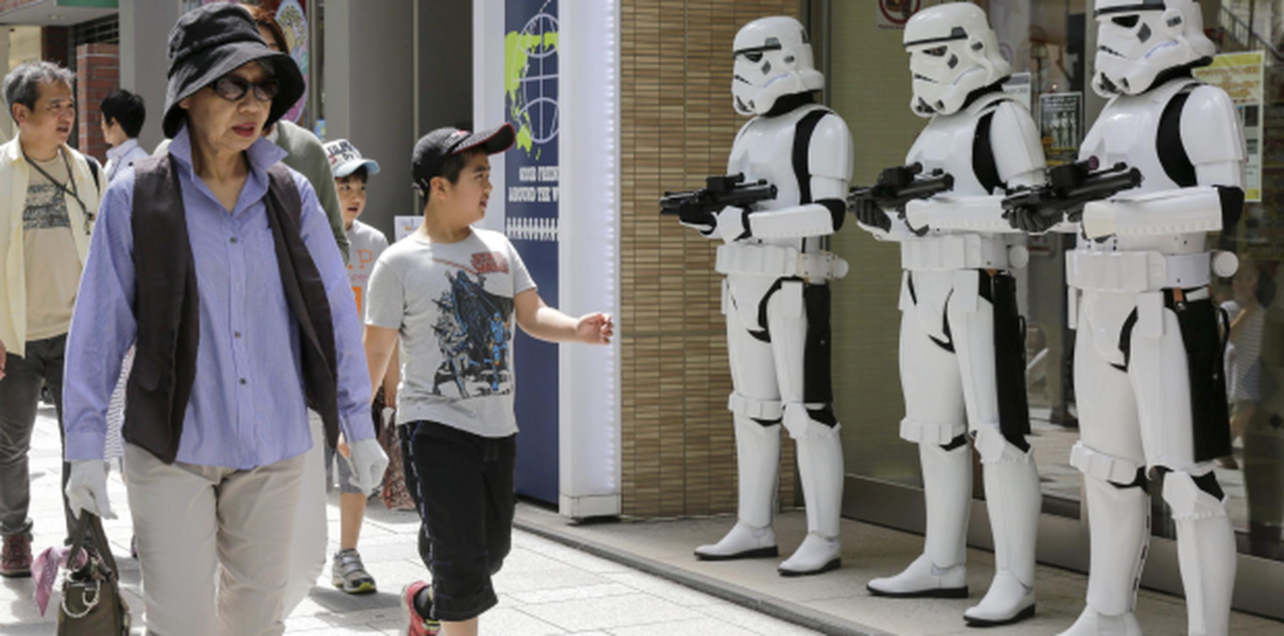 Este niño en Japón con camiseta de Star Wars camina hoy fente a una tienda de juguetes custodiada por Storm Troopers. (AP)