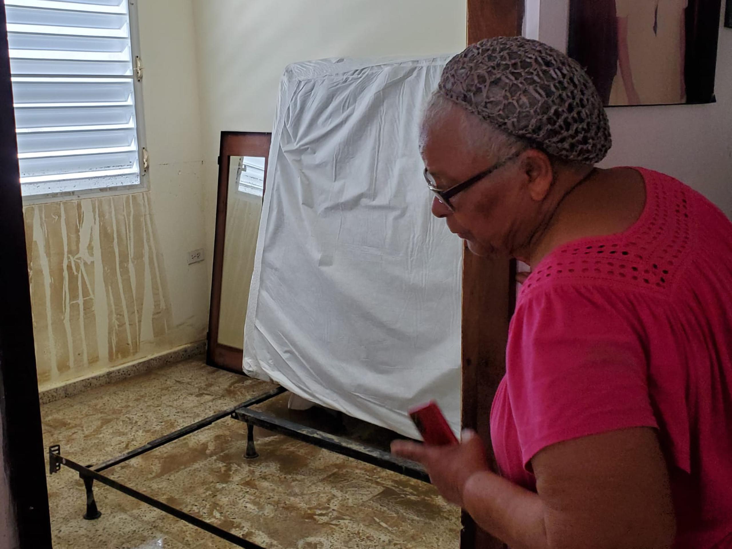 Isolina Santana, del sector Maguayo en Dorado, demuestra los daños en su hogar.