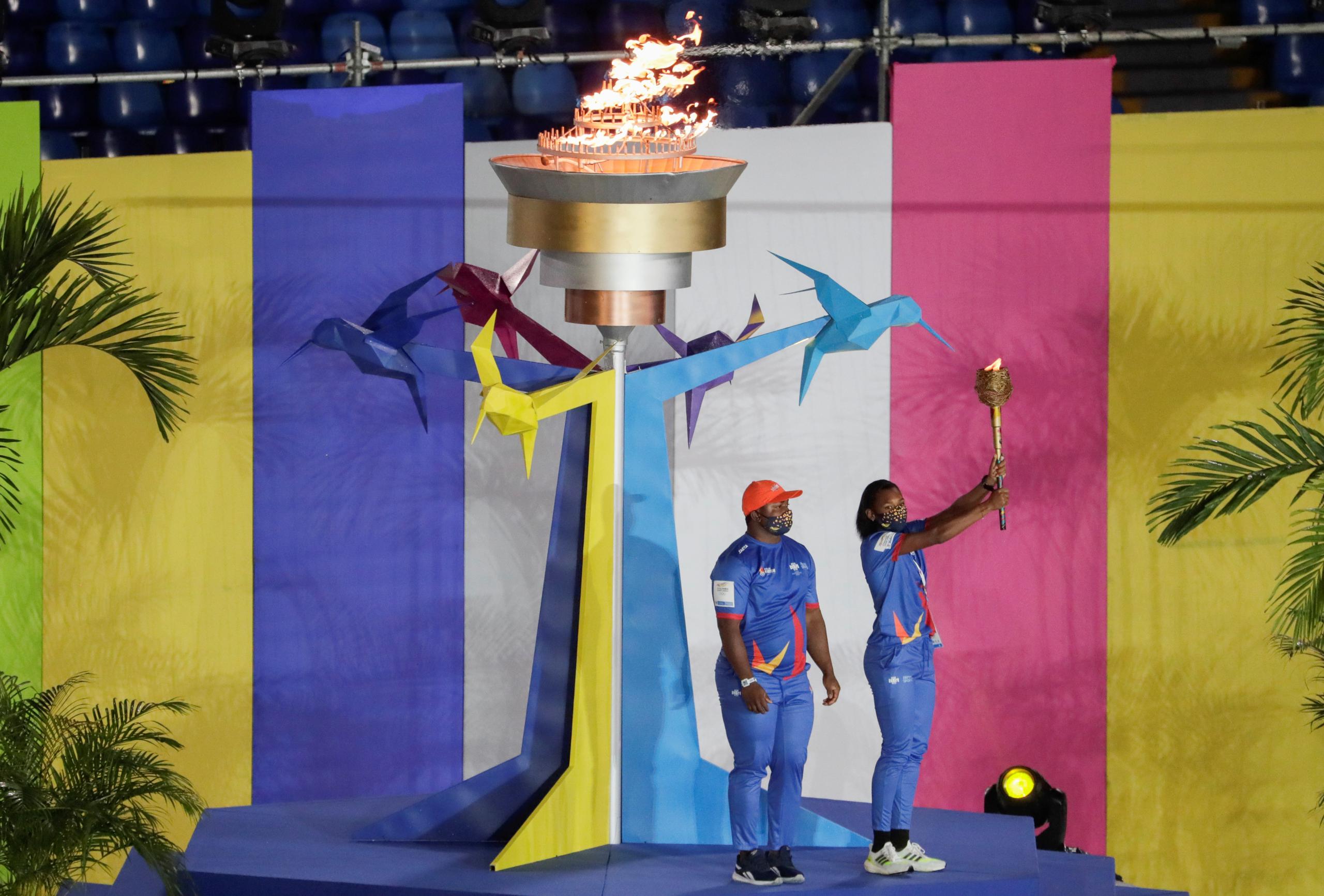 La atleta colombiana Valeria Cabezas sostiene la llama olímpica tras encender el pebetero junto a Juan Manuel Morales durante la ceremonia de apertura de los Juegos Panamericanos Junior.