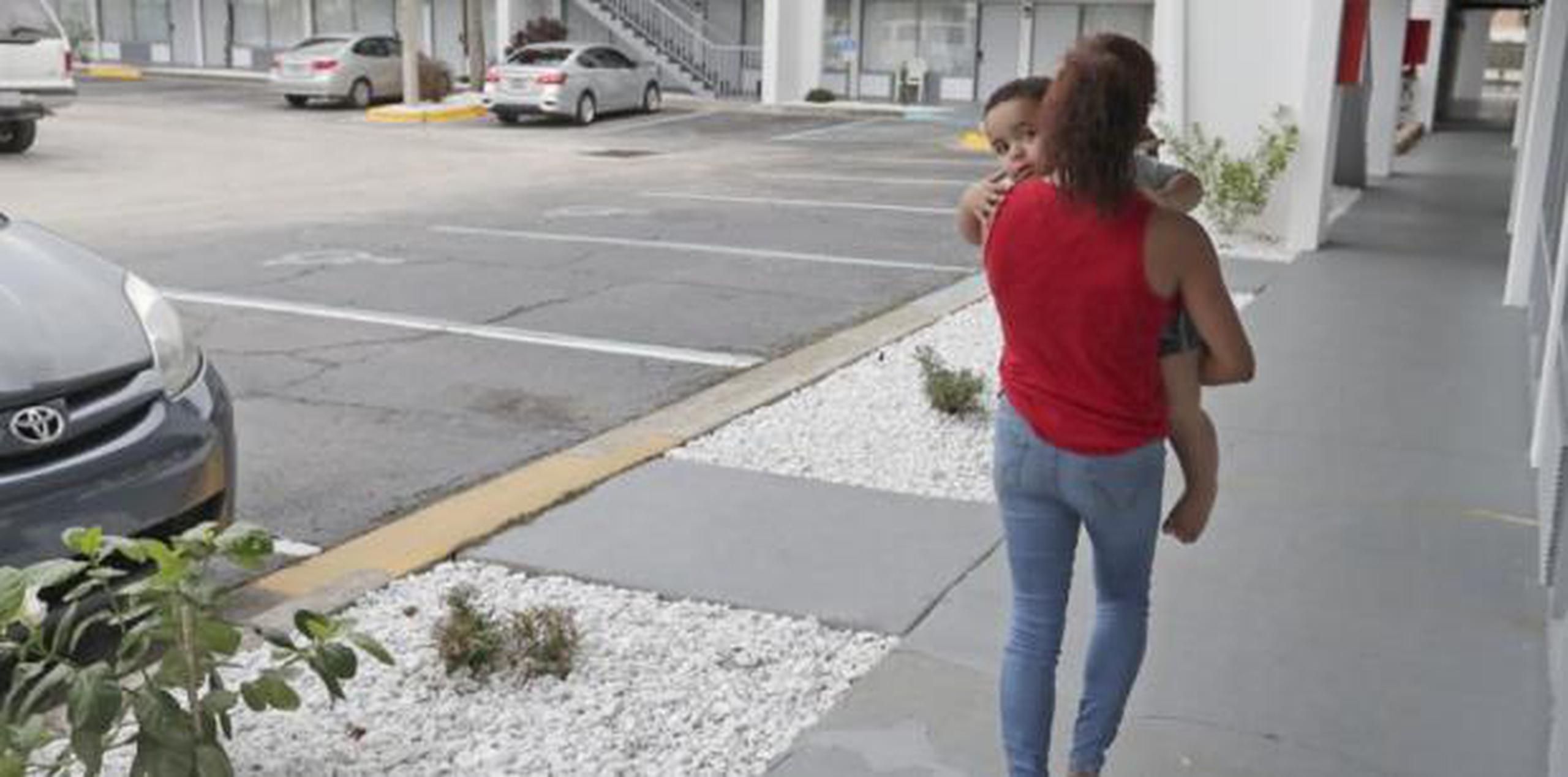 Una puertorriqueña camina por los predios de un hotel que puede pagar para vivir por una ayuda que recibe del gobierno federal que está a punto de expirar. (AP)