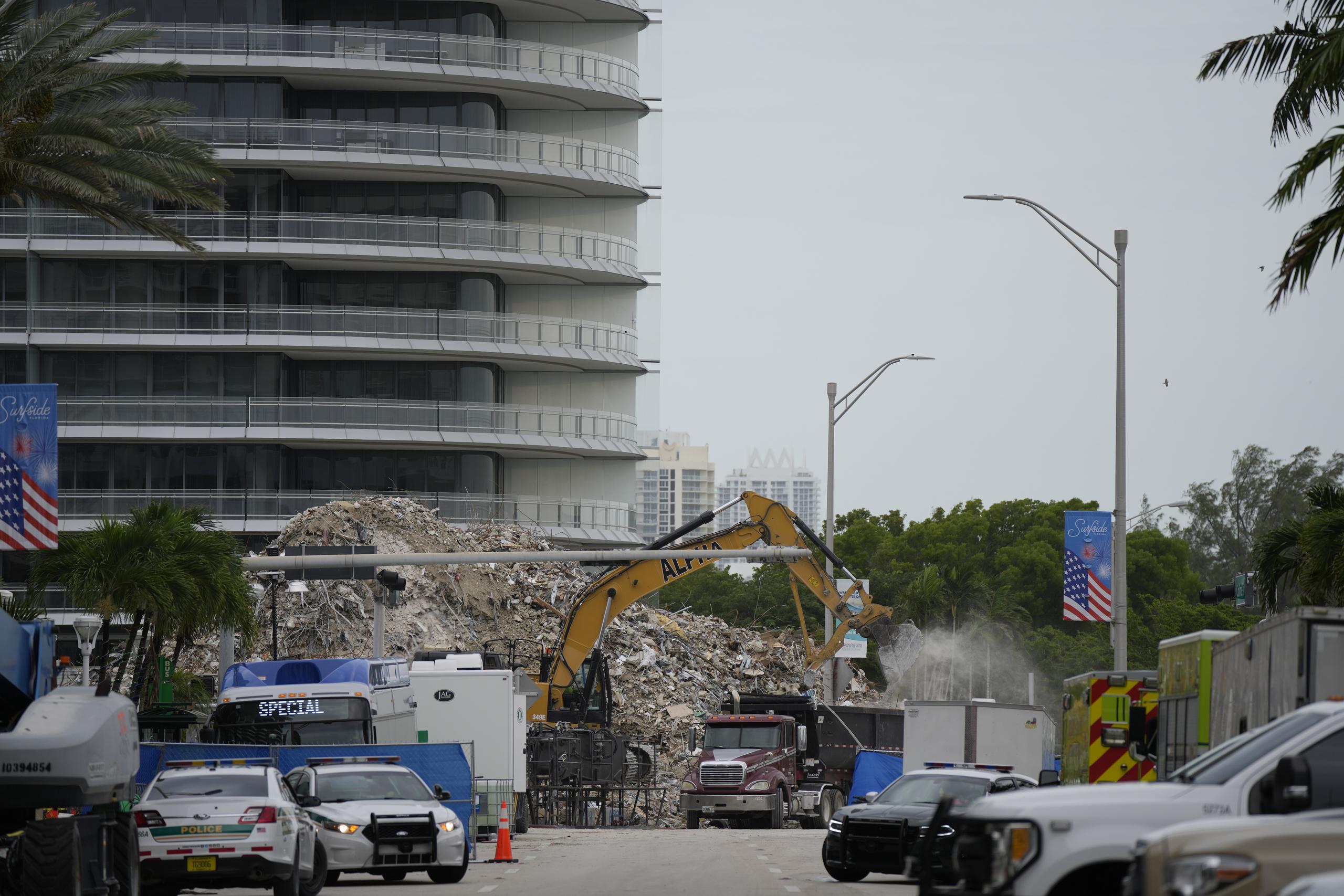 Una excavadora retira escombros de la sección demolida del complejo de condominios Champlain Towers South, mientras prosiguen las labores de recuperación de restos humanos en el lugar, en Surfside, Florida.