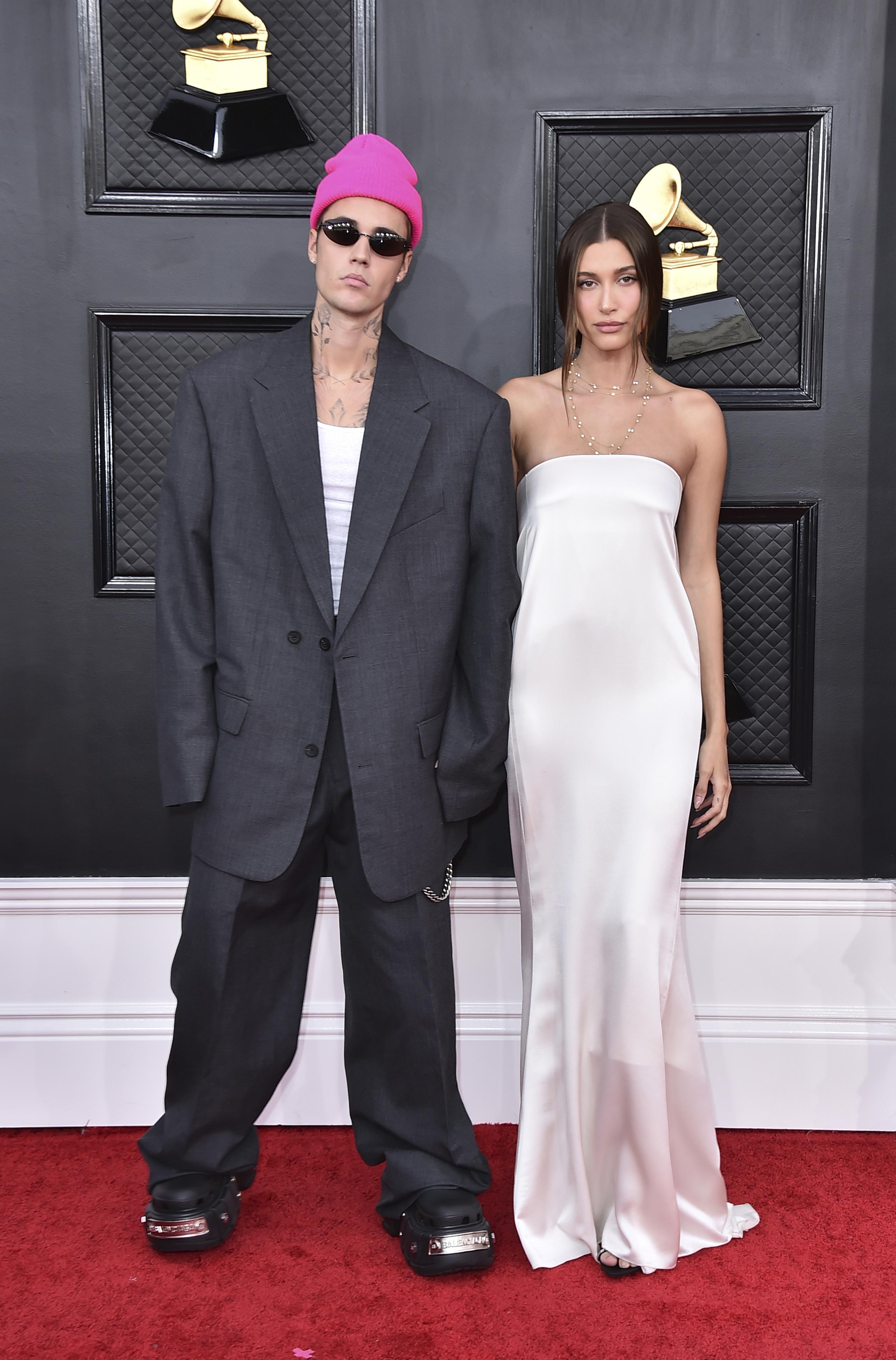 Justin Bieber, en un traje gris holgado y gorro fucsia, llegó con su esposa, Hailey, quien lució un Saint Laurent blanco.