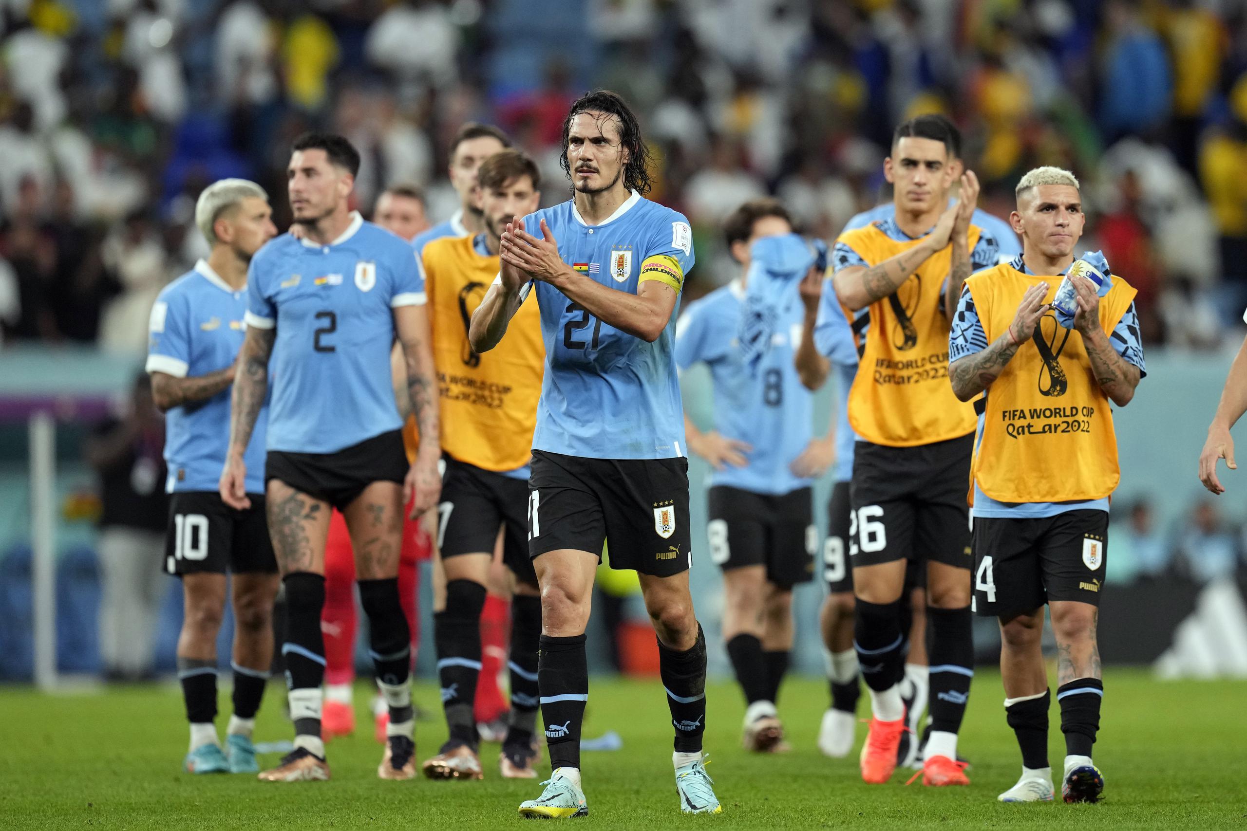 Liderados por Edinson Cavani (21), los jugadores de Uruguay agradecen al público mientras salen del terreno tras conocer que habían quedado eliminados del Mundial de Qatar pese a su triunfo.