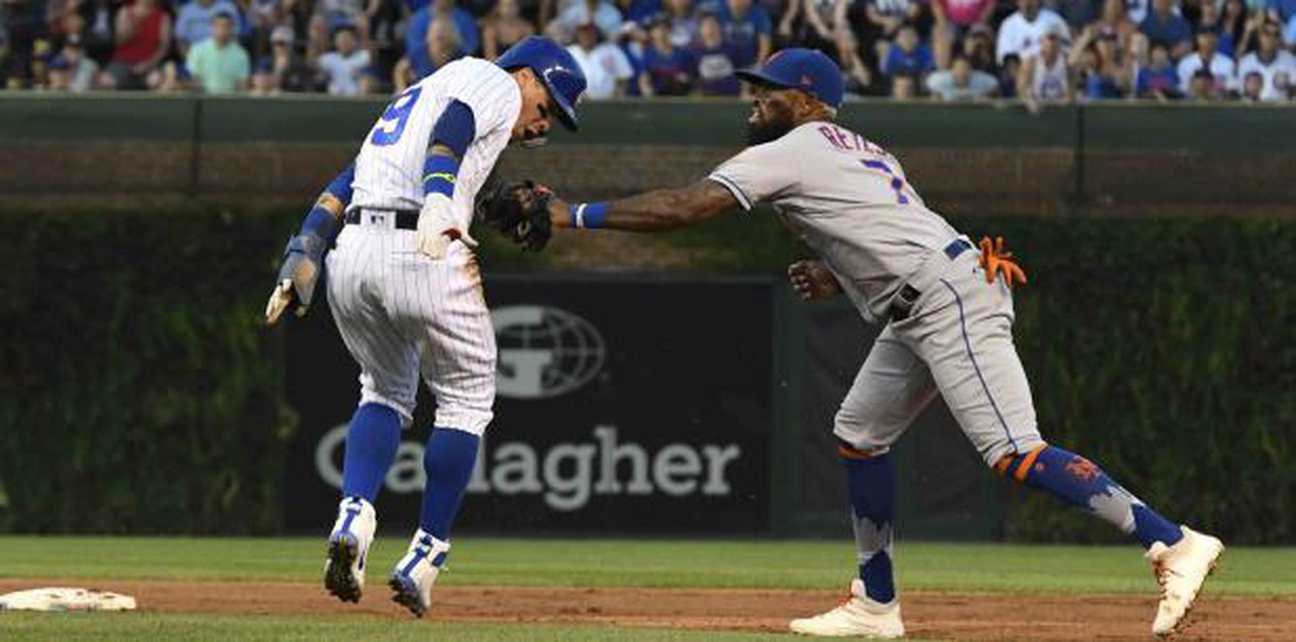 Javier Báez, de los Chicago Cubs, es interceptado por el torpedero de los Mets de Nueva York, José Reyes, mientras intenta robar la segunda base durante la primera entrada. (AP / Matt Marton)