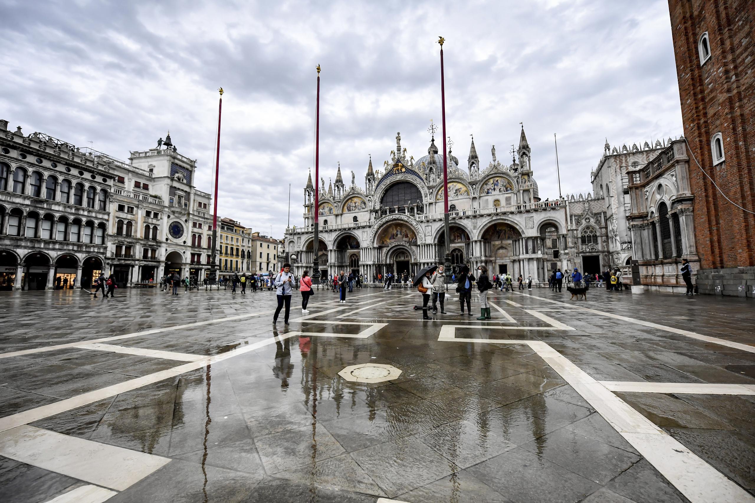 La gente camina por la Plaza de San Marcos de Venecia, Italia, el sábado 3 de octubre de 2020, durante una esperada marea alta.