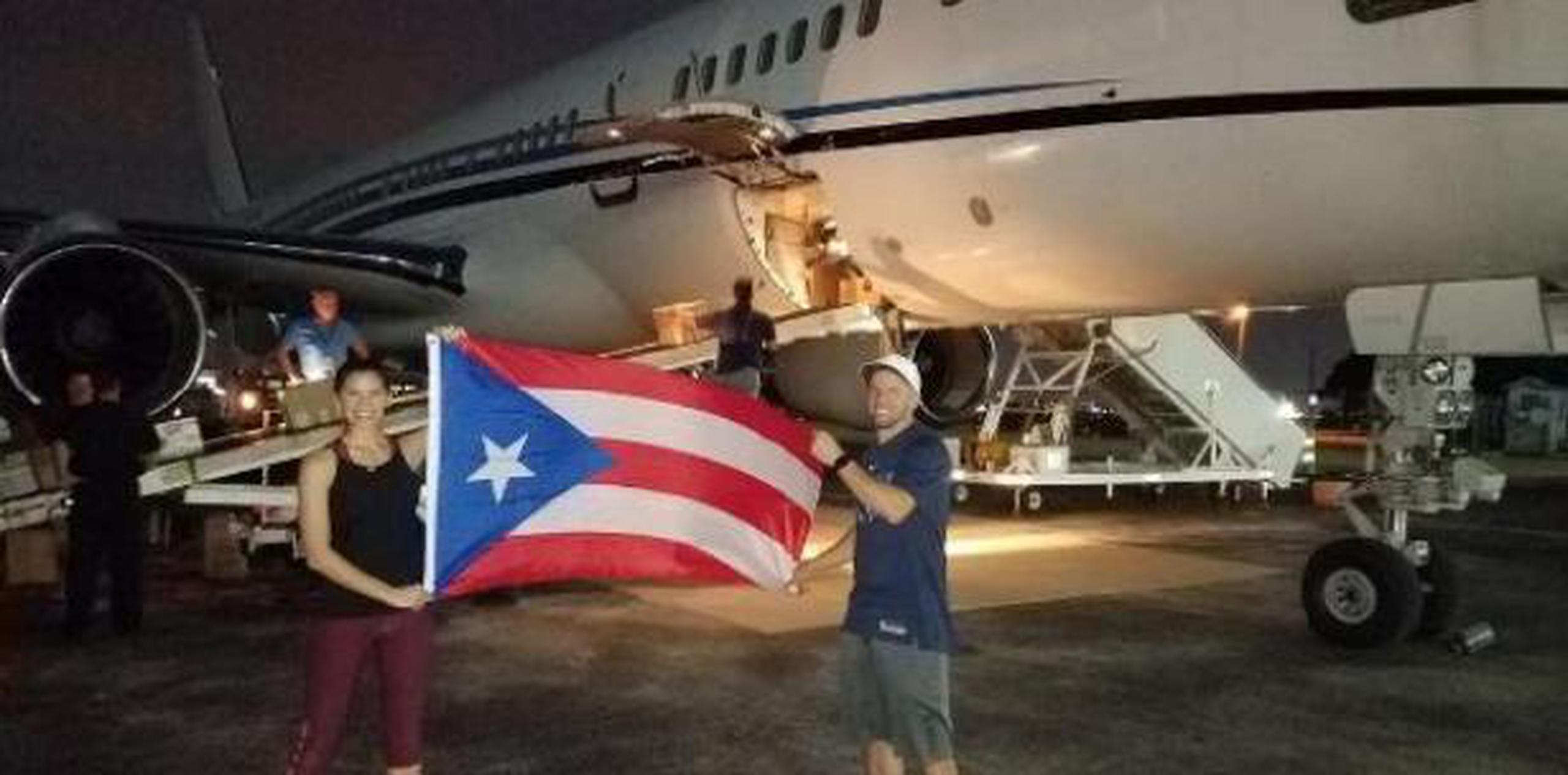 La pareja posó con una bandera de Puerto Rico a punto de salir el primer cargamento de ayuda humanitaria a la isla. (Archivo)