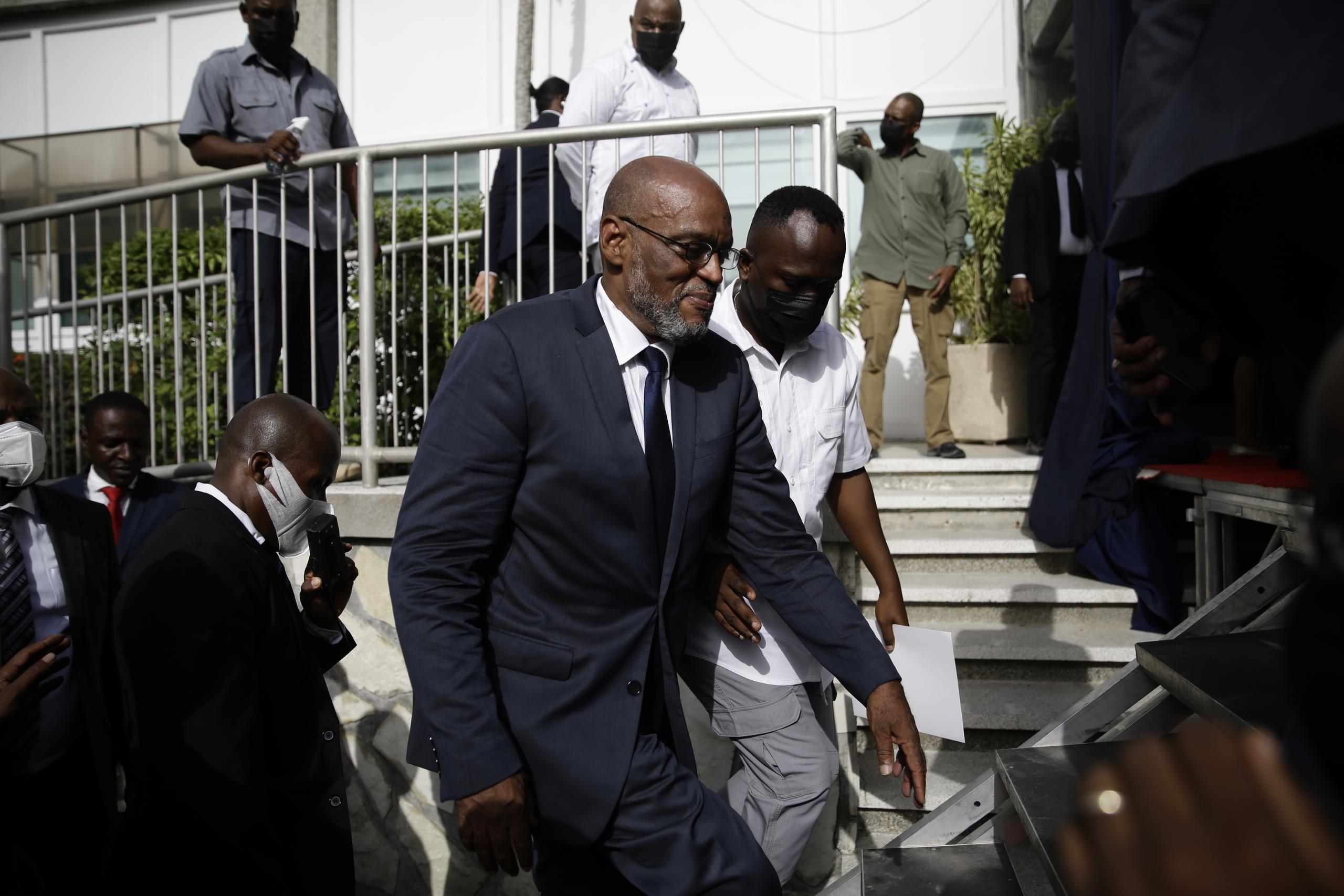 El nuevo primer ministro de Haití, Ariel Henry, sube escaleras acompañado de escoltas después de ser designado al cargo, en Puerto Príncipe.