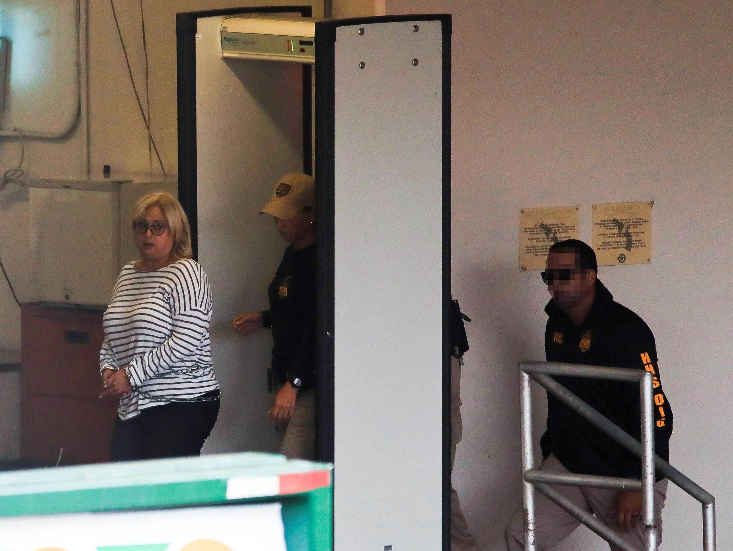 Momento en que la ex directora de la Administración de Seguros de Salud (ASES), Ángela Ávila, es llevada al tribunal federal. (GFR Media)