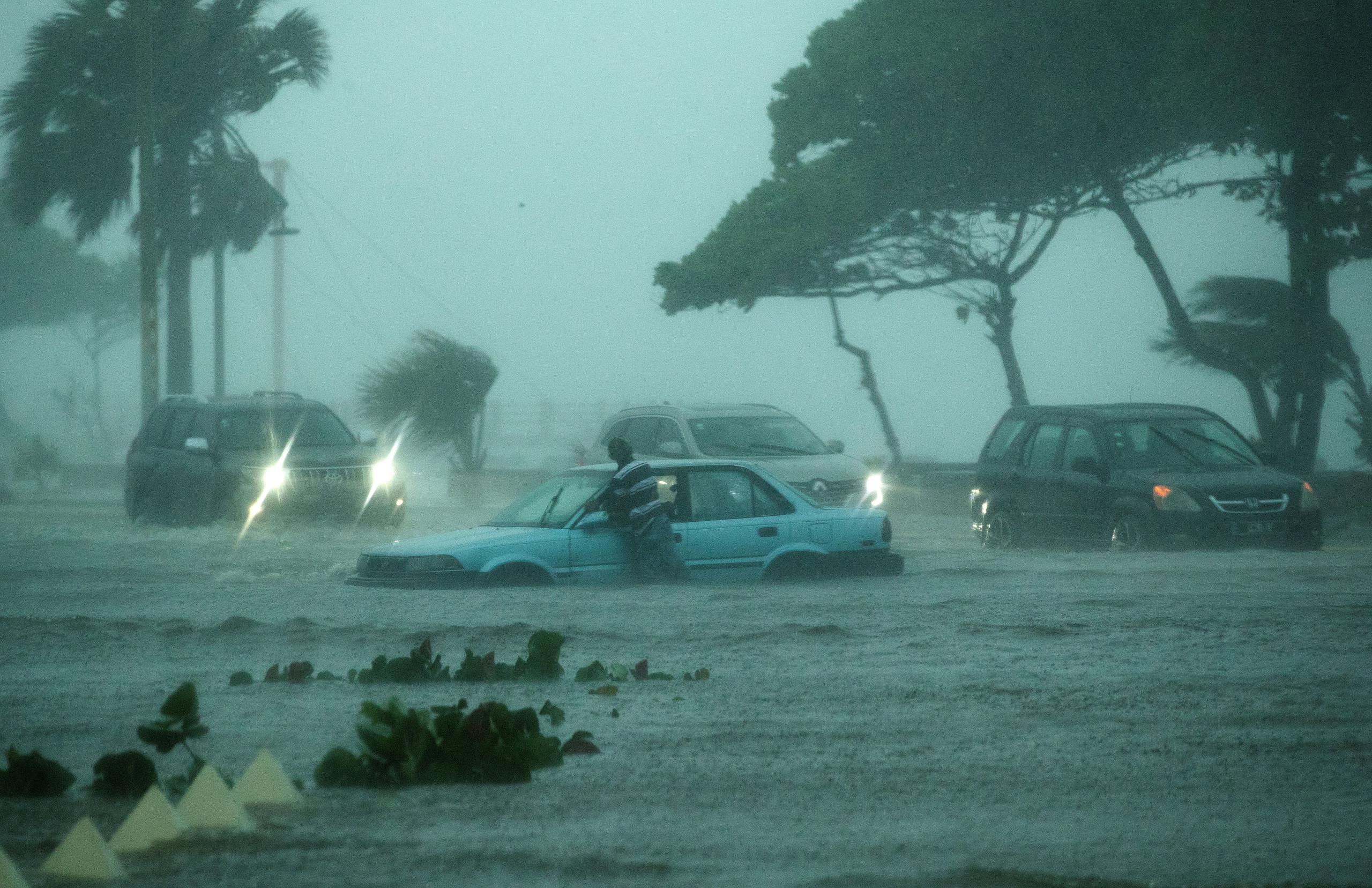 Vehículos circulan bajo la intensa lluvia durante el paso de la tormenta tropical Fred en Santo Domingo, República Dominicana.