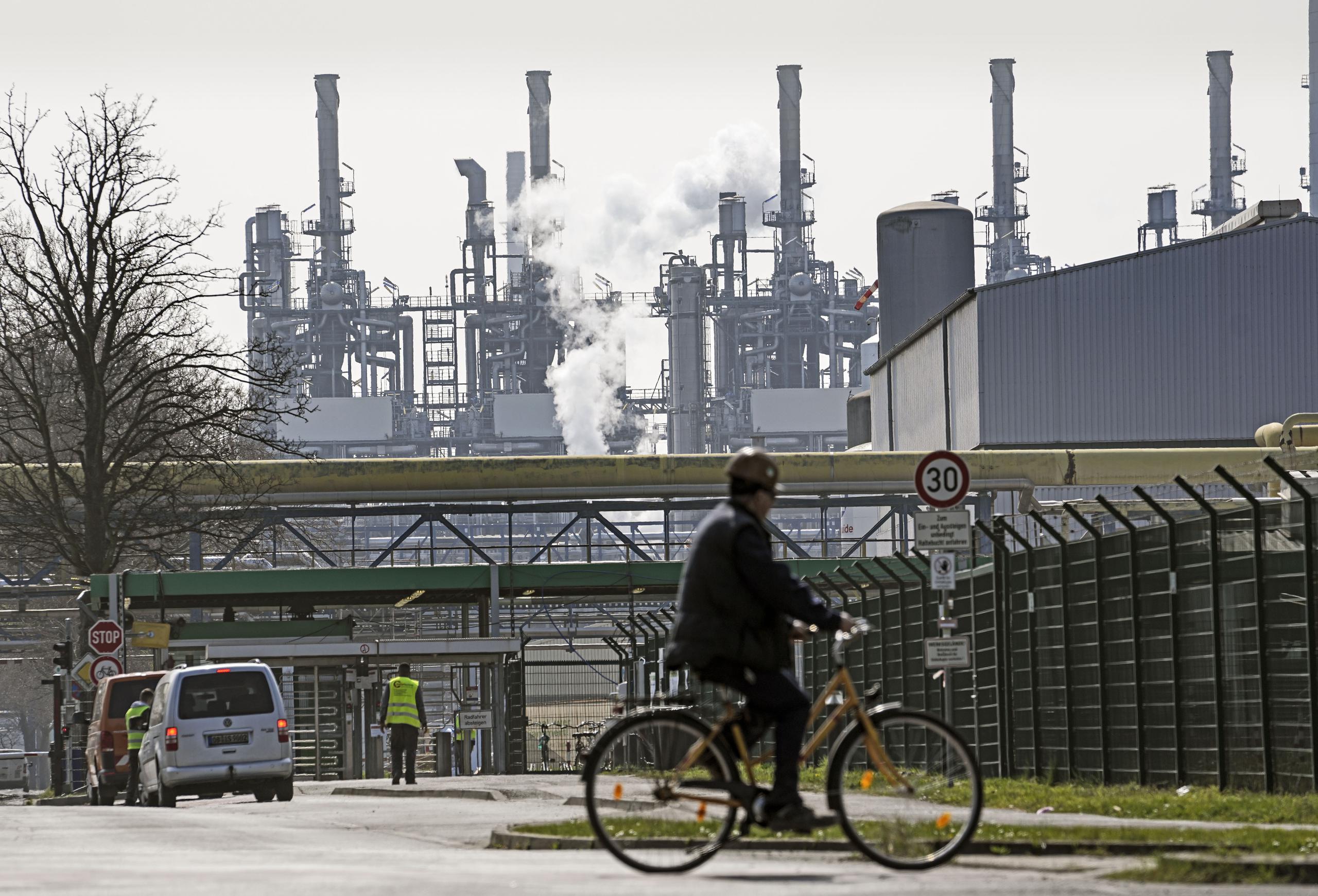 Una persona llega en bicicleta a la refinería BP Ruhr Oil en Gelsenkirchen, Alemania, el lunes 28 de marzo de 2022. (AP Foto/Martin Meissner)