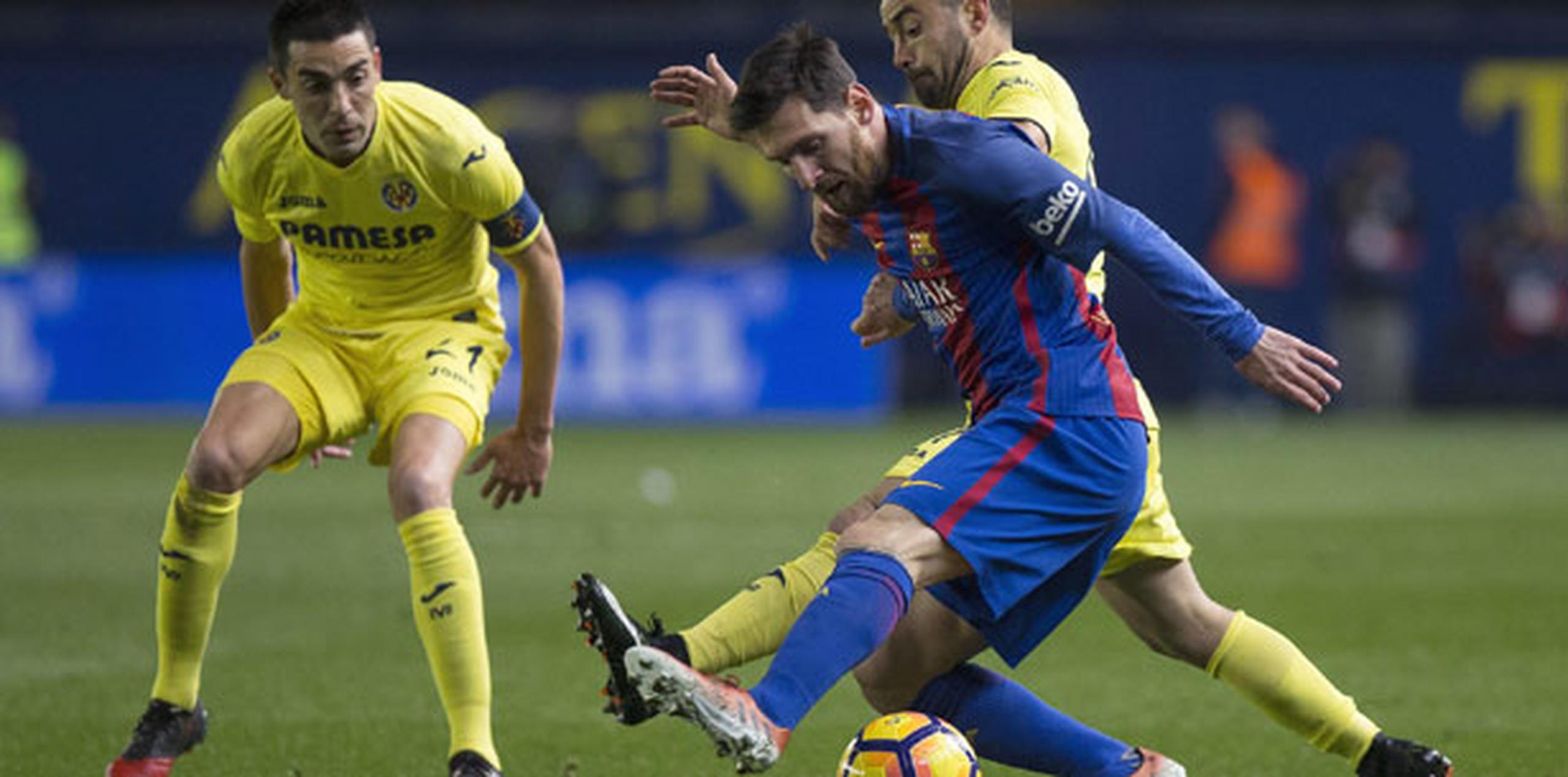 El delantero argentino del F. C. Barcelona, Leo Messi (derecha), intenta llevarse el balón ante los jugadores del Villarreal, Jaume Costa (detrás) y Bruno Soriano. (EFE / Domenech Castelló)