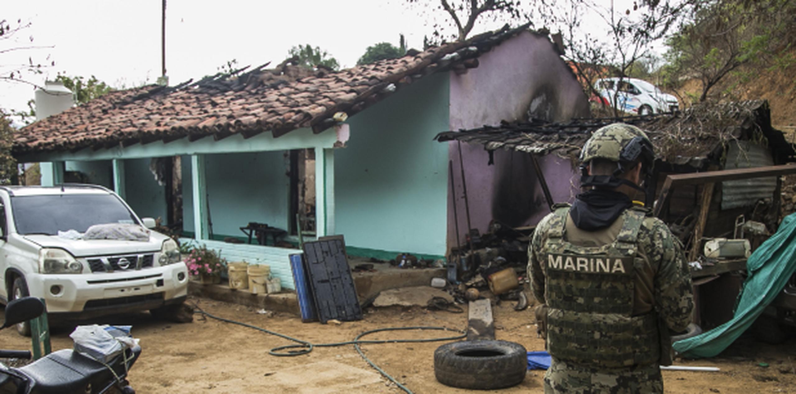 Un soldado vigila cerca de una residencia baleada en la comunidad donde, según el alcalde, han salido huyendo de sus domicilios unas 150 familias. (EFE)