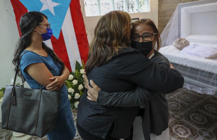 La viuda de Robert Rabin, Nilda Medina (de frente a la derecha), recibió las condolencias y muestras de afecto de decenas de personas que llegaron a la funeraria.