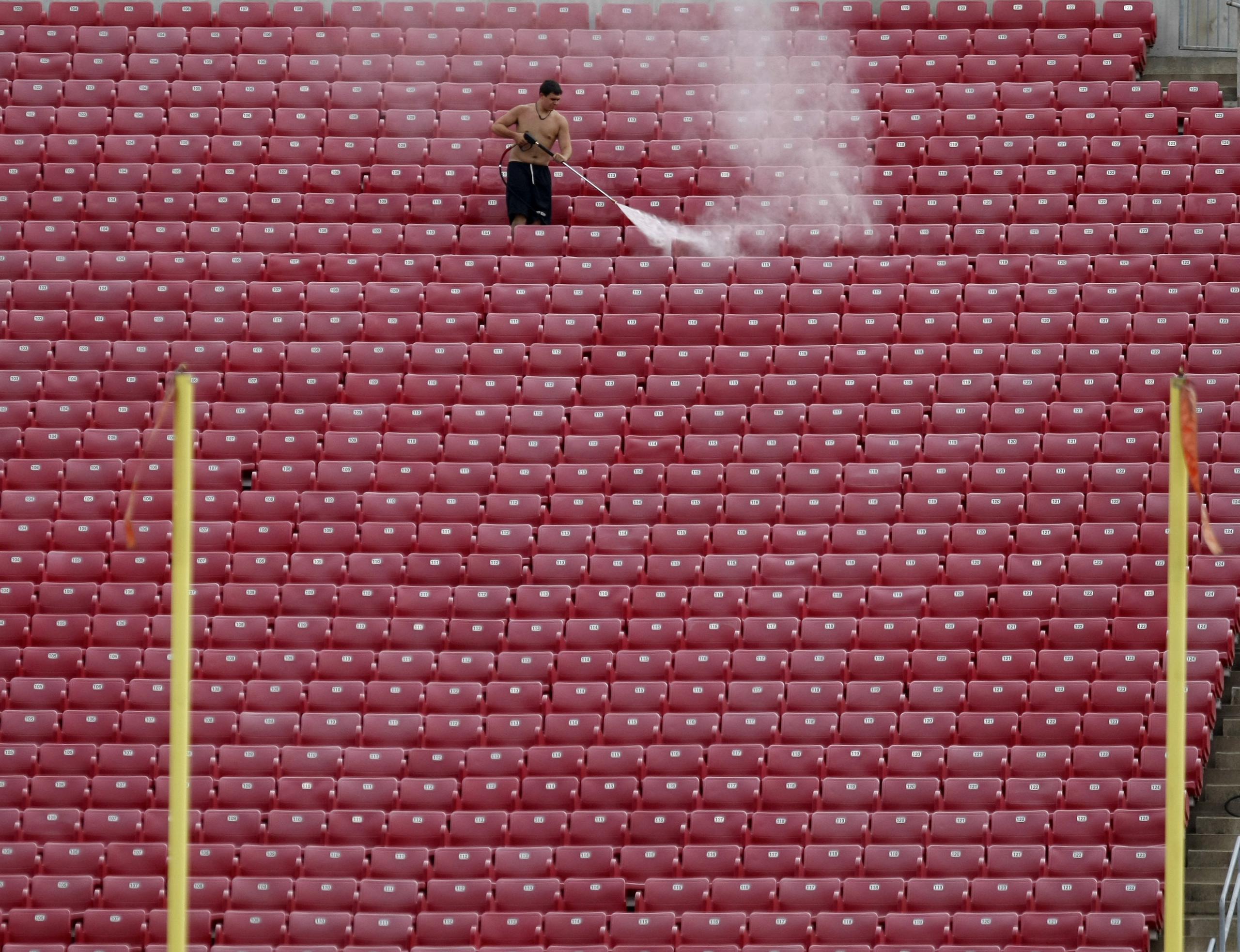 En esta imagen del 7 de agosto de 2011, un trabajador limpia a presión los estadios en el Estadio Papa John's antes del juego de fútbol americano colegial en Louisville, Kentucky.