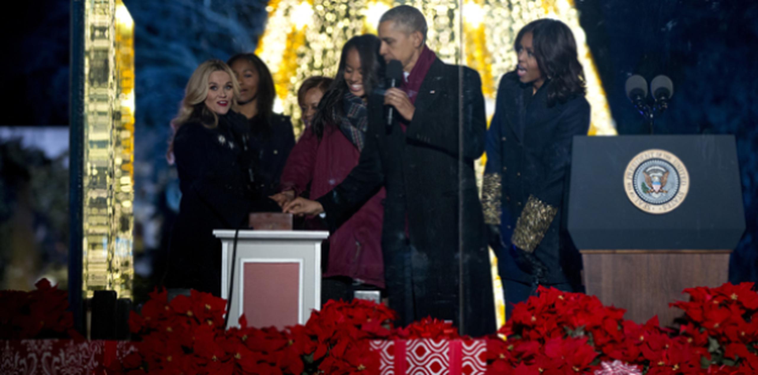 La actriz Reese Witherspoon acompaña a Sasha Obama, Marian Robinson, Malia Obama, el presidente Barack Obama y la primera dama Michelle Obama tras encender el árbol de la Casa Blanca. (AP)
