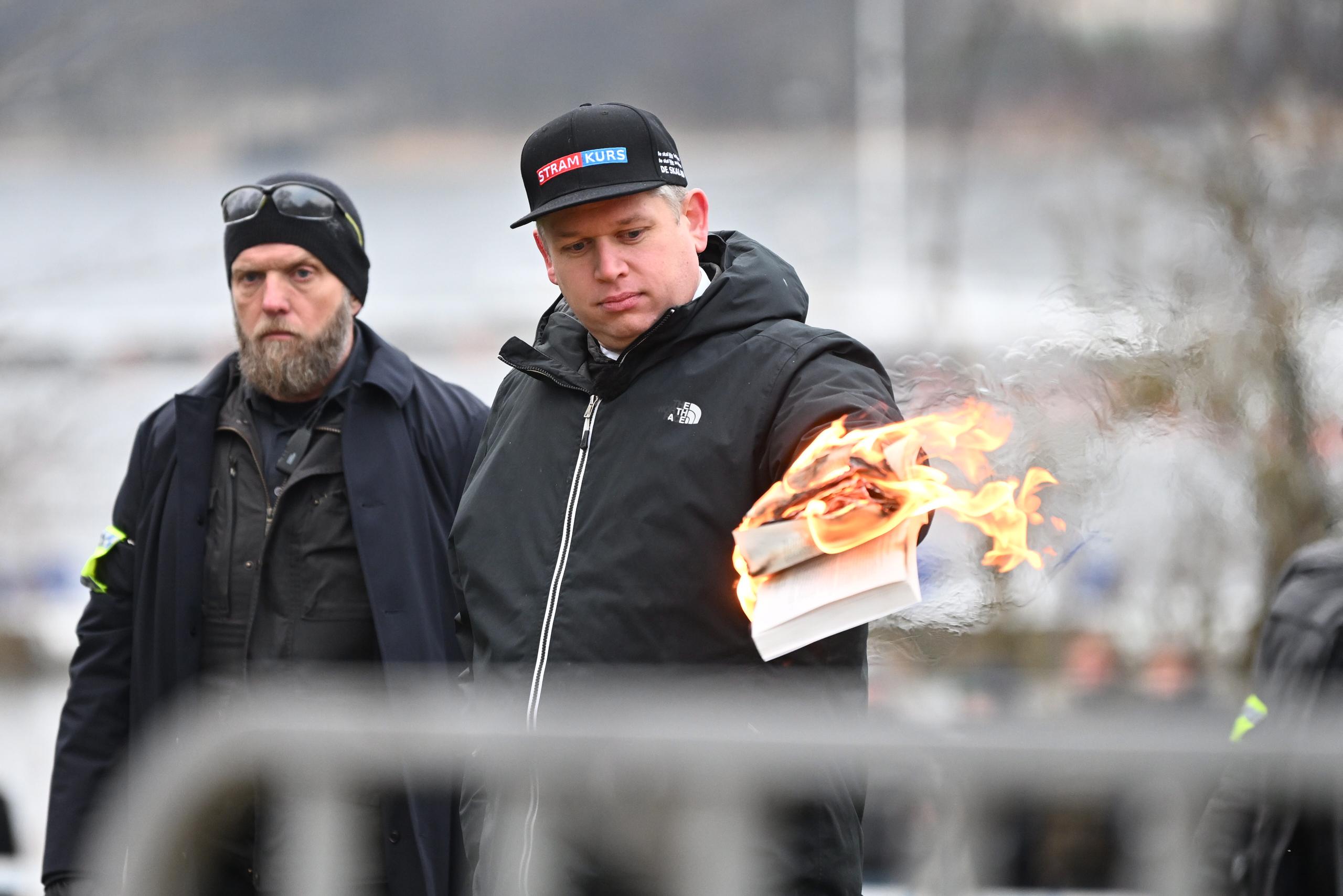 El líder del partido danés de extrema derecha Rumbo Firme, Rasmus Paludan, quema una copia del Corán enfrente de la embajada turca en Estocolmo. EFE/EPA/Fredrik Sandberg/

