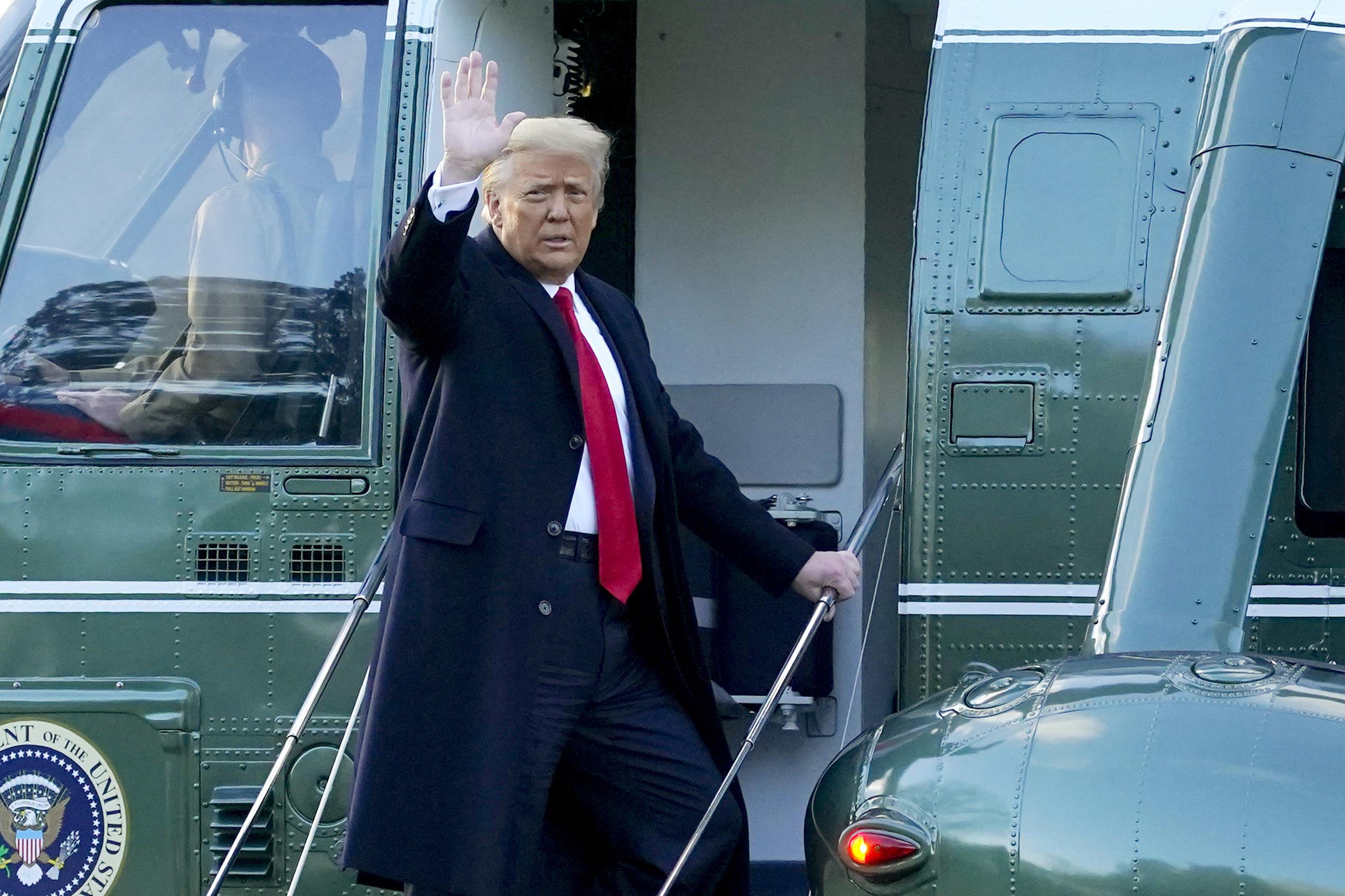 El presidente saliente Donald Trump se despide mientras aborda el helicóptero Marine One para salir de la Casa Blanca.
