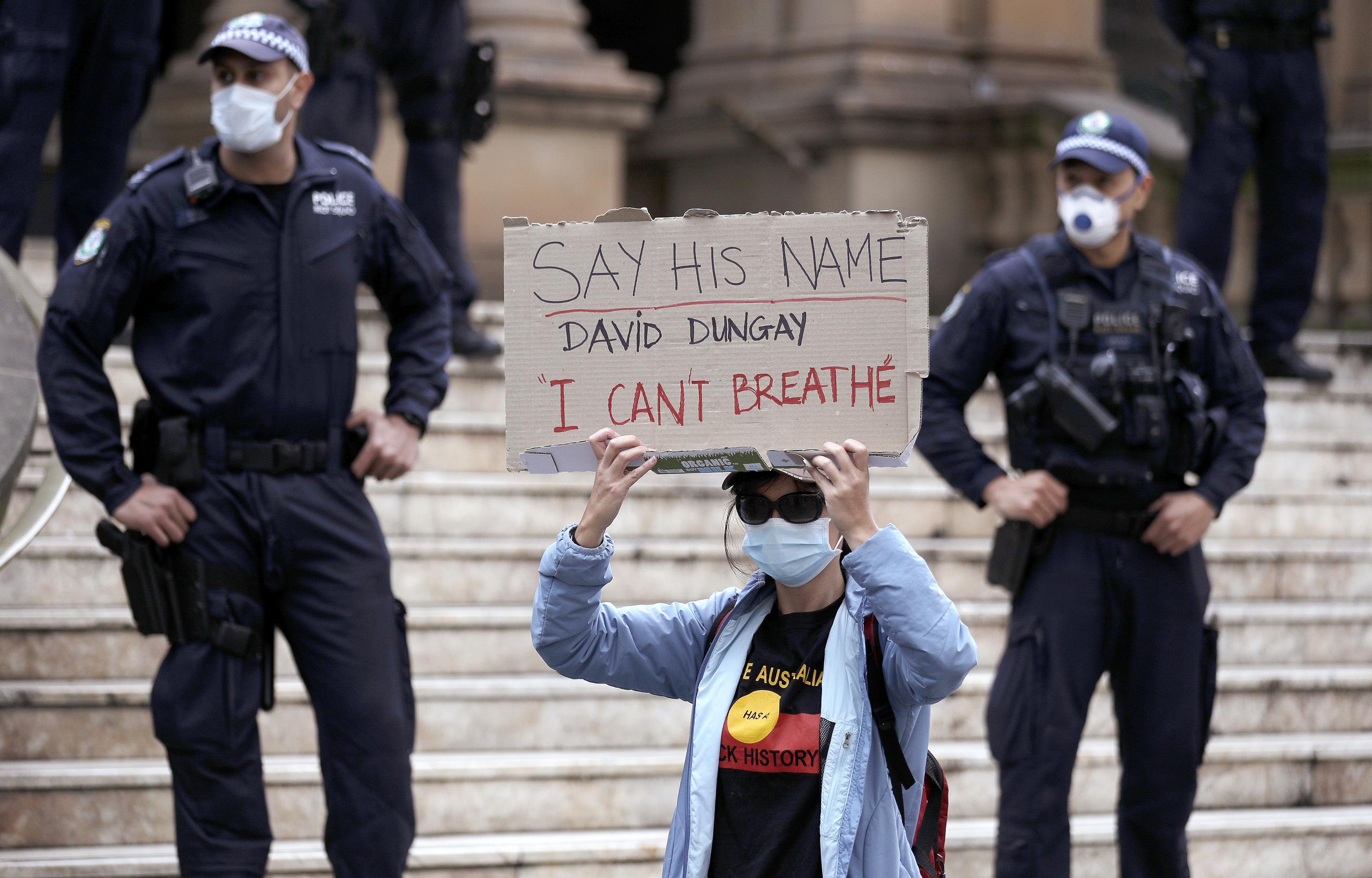 Una mujer sostiene un cartel durante una movilización del movimiento Black Lives Matter en Sydney, Australia.