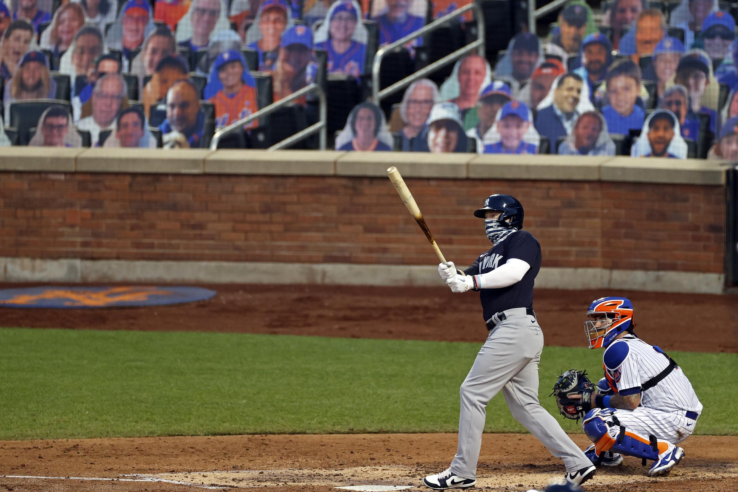 Clint Frazier, de los Yankees, observa la trayectoria de su jonrón de dos carreras contra los Mets con las imágenes de fanáticos de fondo en el Citi Field de Nueva York.
