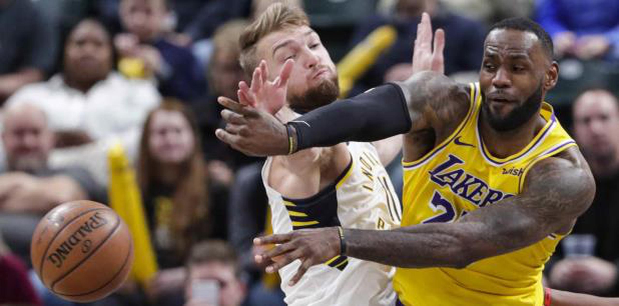 LeBron James, de los Lakers, realiza un pase ante la cerrada defensa de Domantas Sabonis, de los Pacers, durante el partido que dominó Indiana 105-102 el martes. (AP / Michael Conroy)