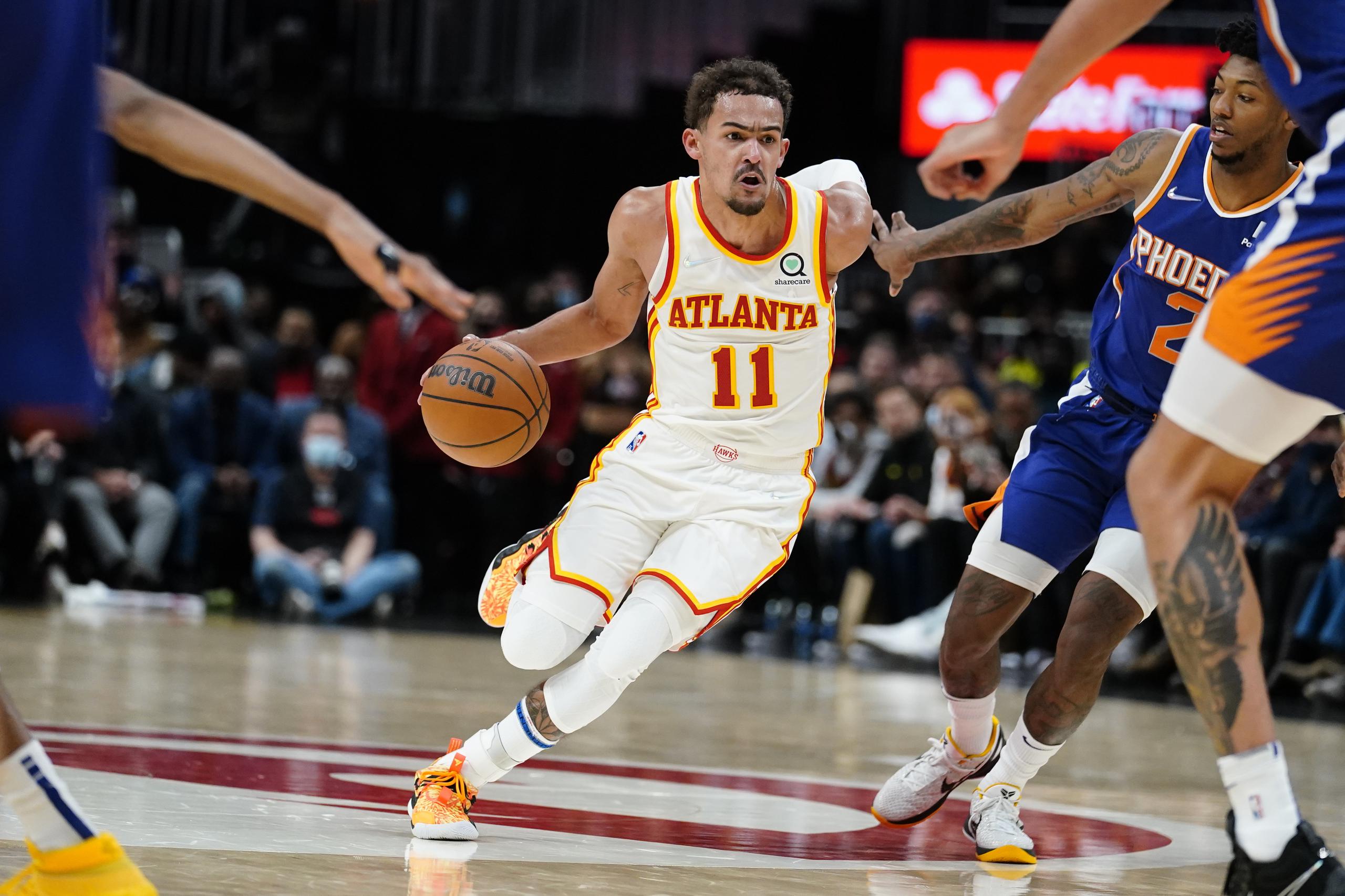 El defensa de los Hawks de Atlanta, Trae Young (11), deja atrás la defensa de Elfrid Payton, de los Suns de Phoenix, de camino a colar dos de los 43 puntos que acumuló el jueves.