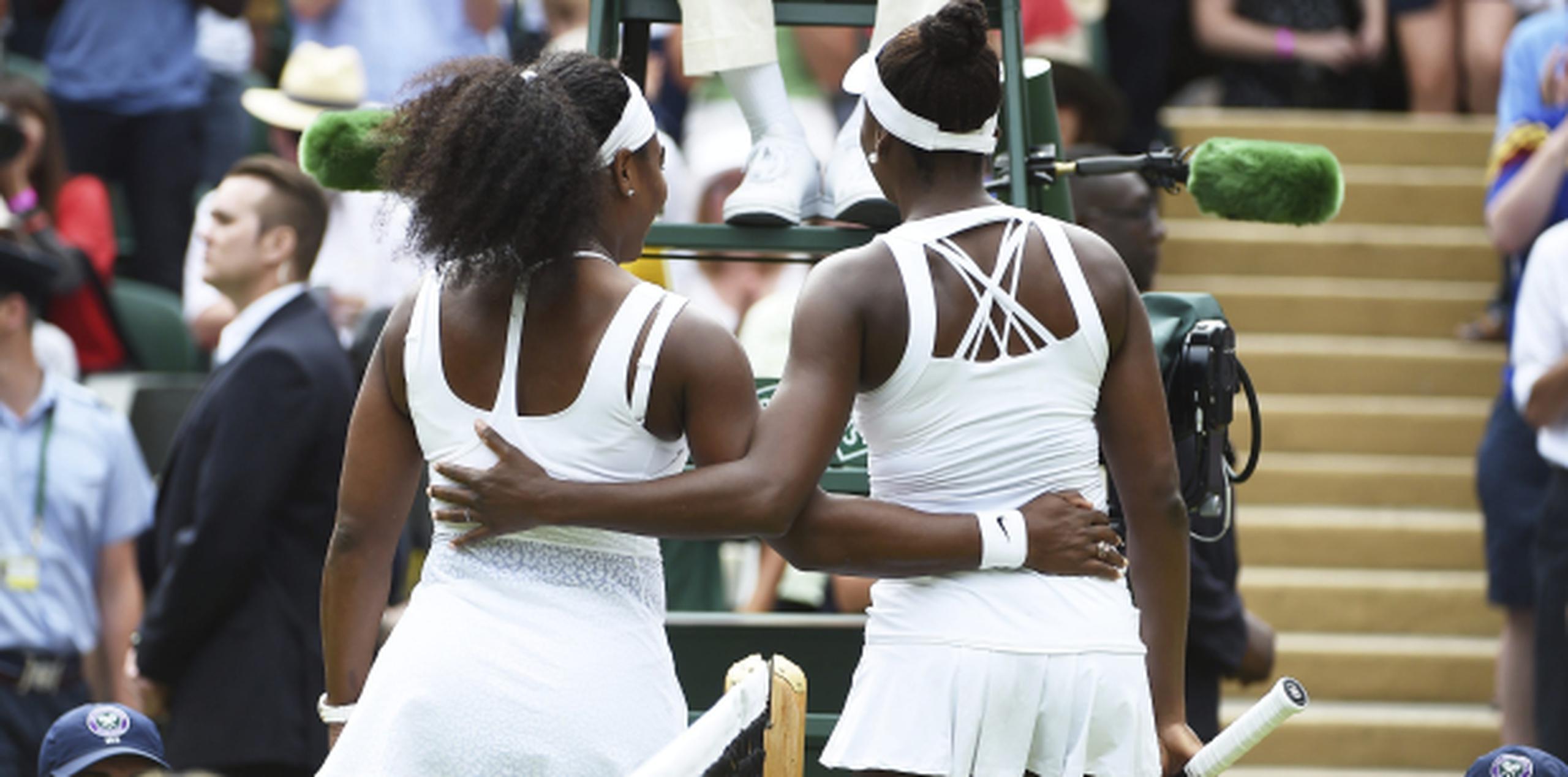 Serena Williams, a la izquierda, abraza a su hermana Venus tras vencerla en un partido de cuarta ronda el Torneo de Wimbledon. (EFE)