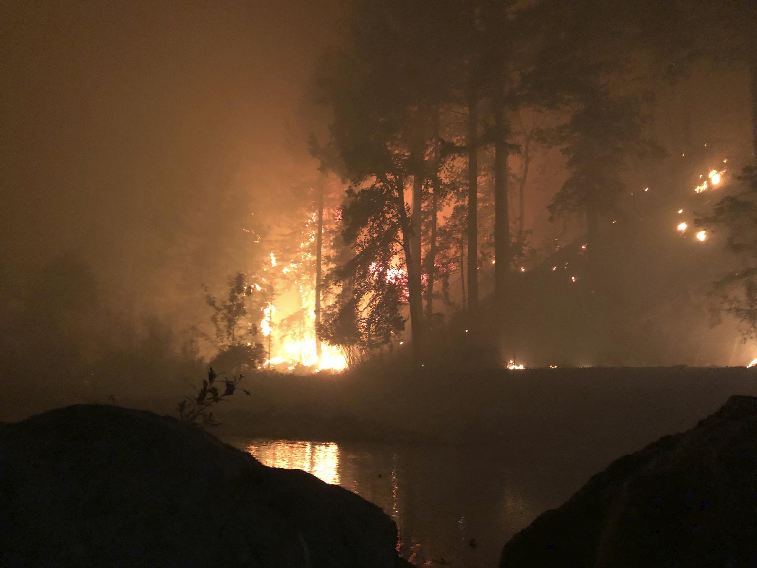 Esta fotografía fue tomada por Don Myron que se refugió de un incendio forestal mortífero sobre una roca mientras se protegía con una silla de plástico a la mitad del río Little North Santiam tras huir de su casa en Lyons, Oregon.