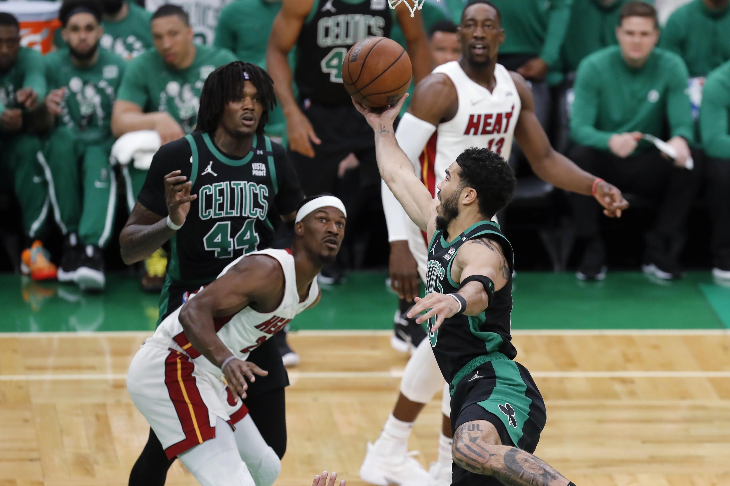 En foto del viernes 27 de mayo del 2022, Jayson Tatum de los Celtics de Boston lanza el balón sobre Jimmy Butler del Heat de Miami en el juego 6 de las Finales de la Conferencia Este. (AP Photo/Michael Dwyer)