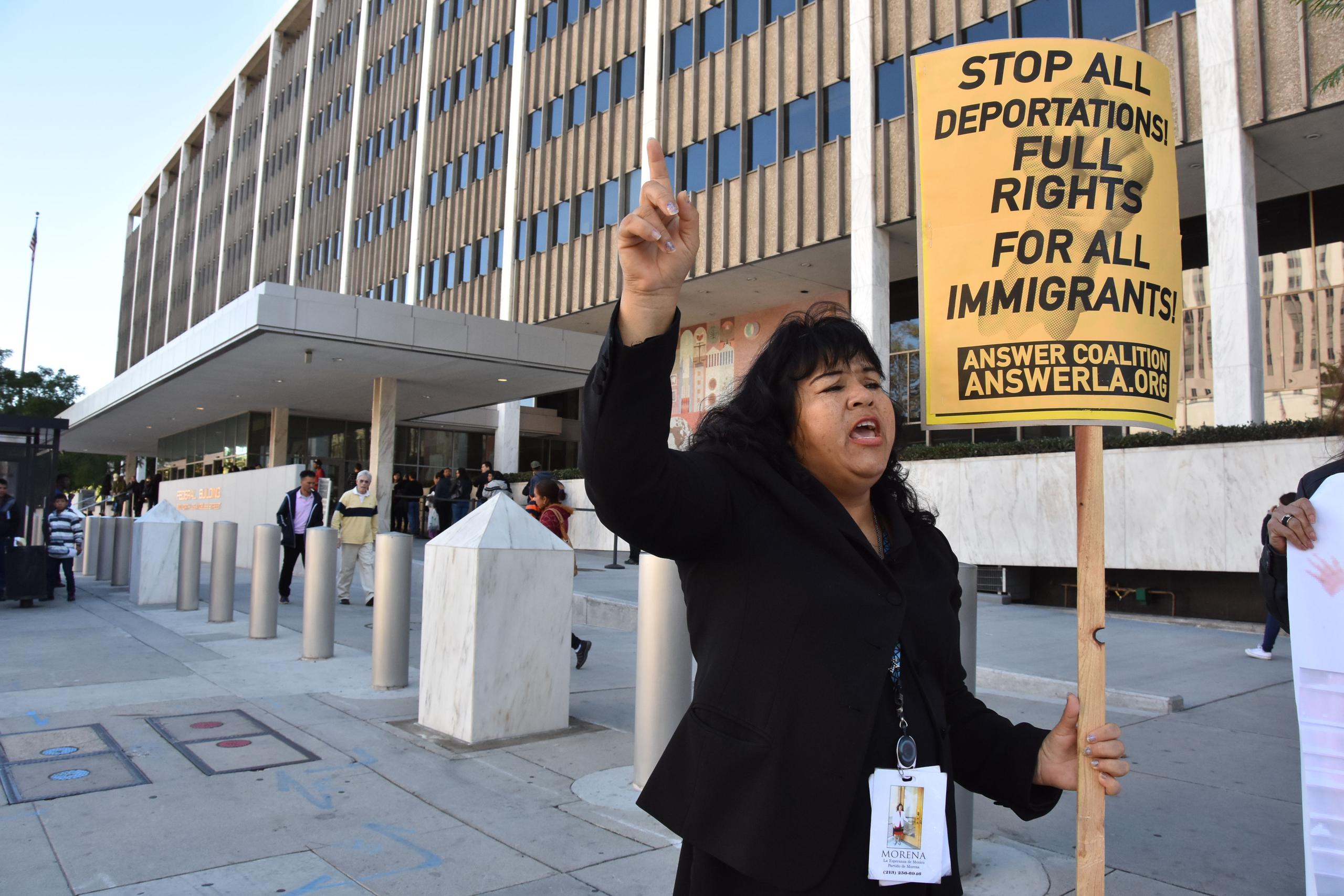 Una mujer realiza una protesta frente al frente al edificio del Servicio de Ciudadanía e Inmigración (USCIS) en Los Ángeles, California.