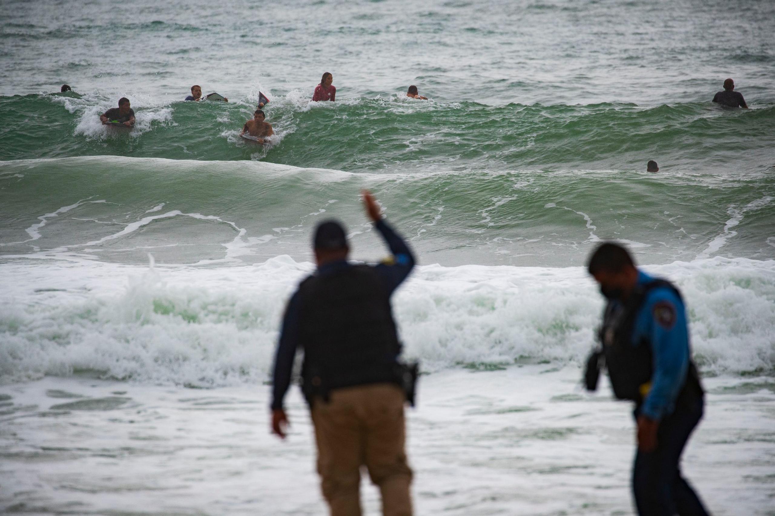 La Policía interviene con surfistas en la playa Aviones en Carolina durante el paso de la tormenta tropical Laura.