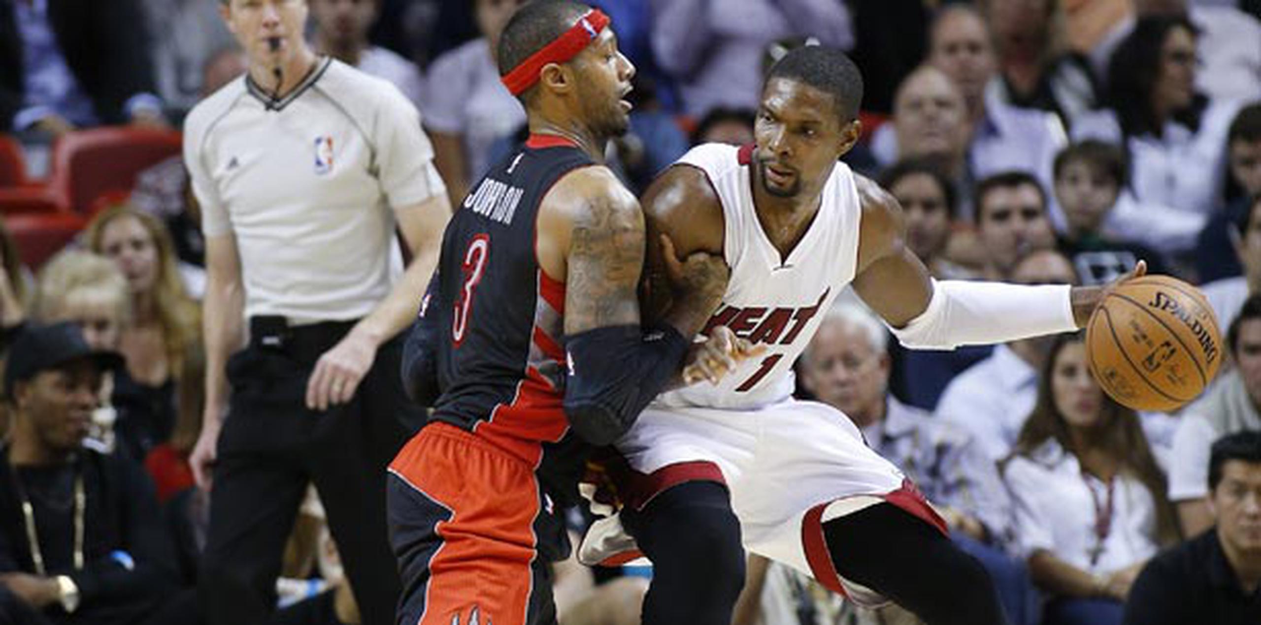 Chris Bosh (con el balón) anotó 21 puntos y descolgó 11 rebotes para el triunfo de anoche del Heat de Miami. (AP)