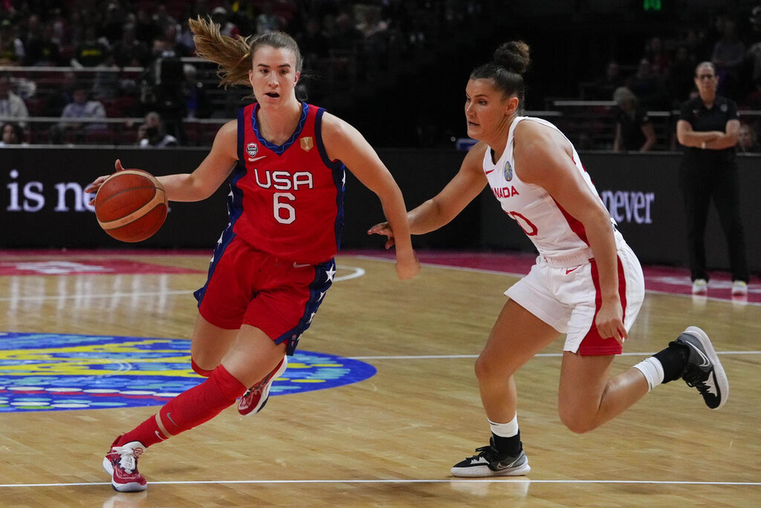 La estadounidense Sabrina Ionescu intenta dejar atrás a la canadiense Taya Hanson en el partido de las semifinales del Mundial de baloncesto femenino.