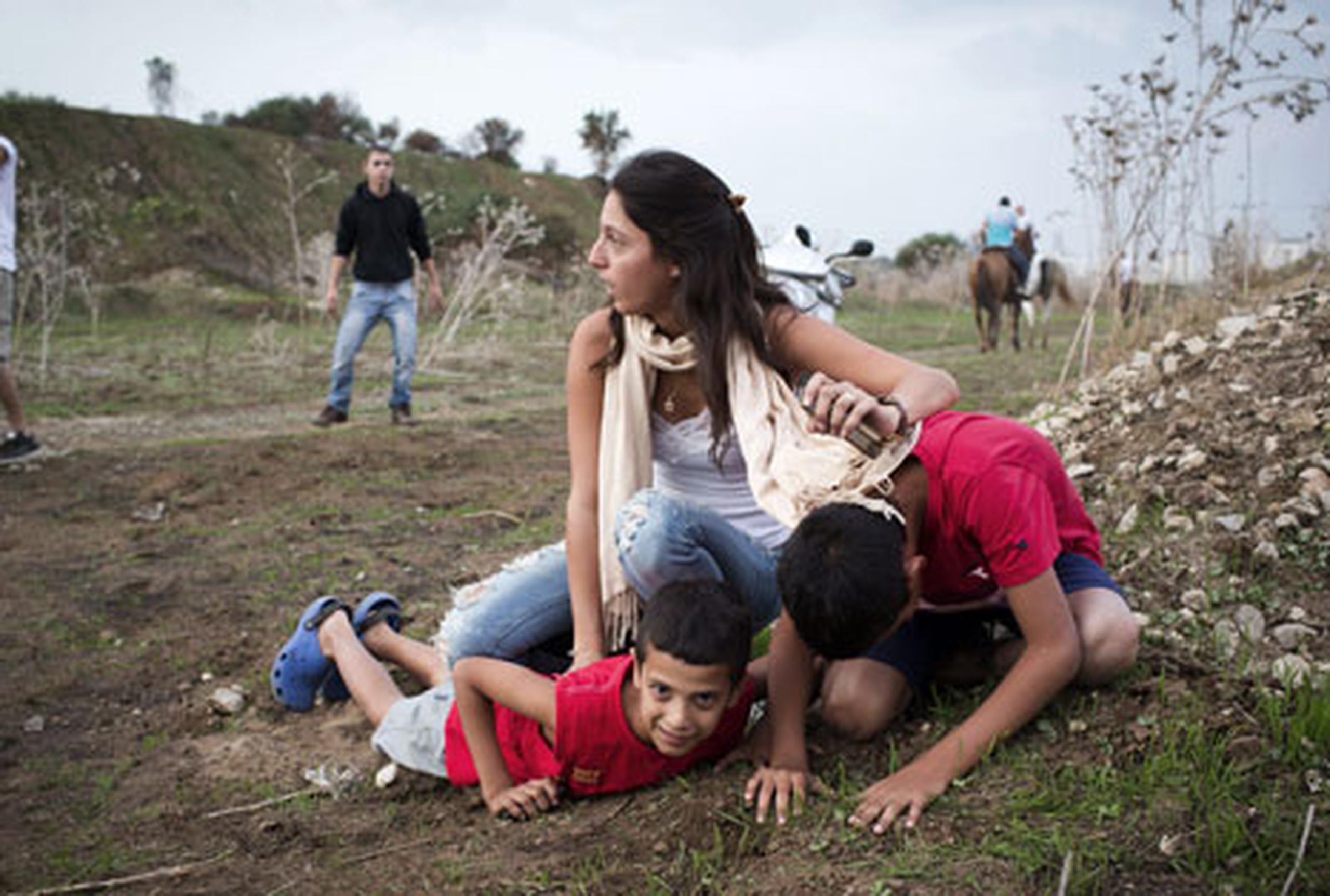 En la foto una israelí  y sus niños se protegen al escuchar la sirena. La misma avisa ataques de cohetes por parte de los militares palestinos. (AFP/Oren Ziv)
