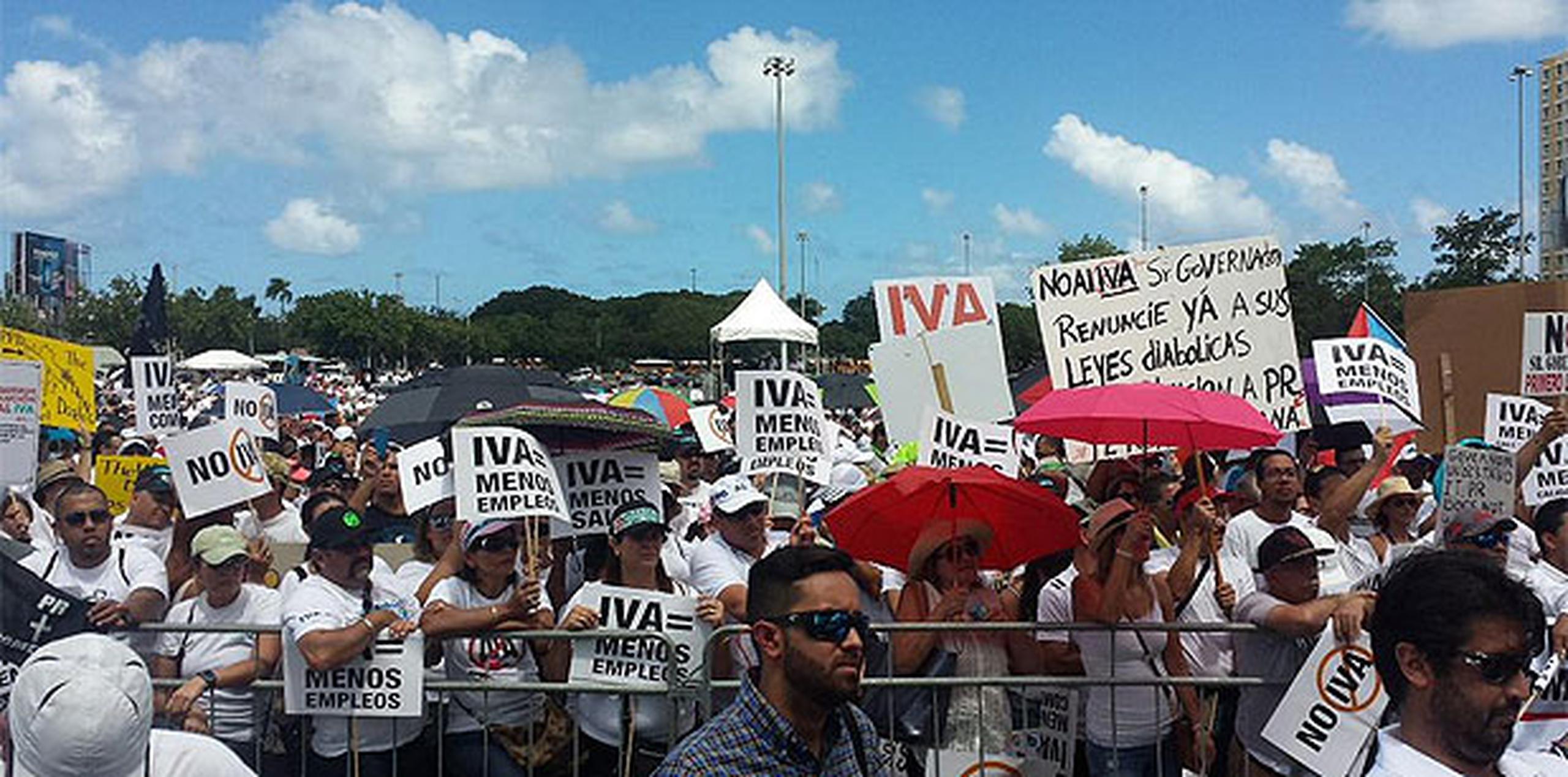Los manifestantes se congregaron frente a una tarima colocada en el estacionamiento del complejo deportivo para escuchar consignas y mensajes en contra del IVA. (daniel.rivera@gfrmedia.com)
