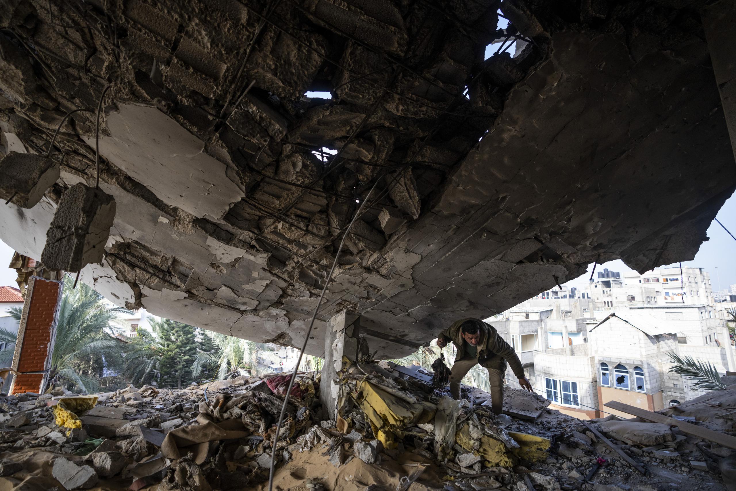 Un palestino busca entre las pertenencias tras un ataque israelí en Rafah, en la Franja de Gaza.